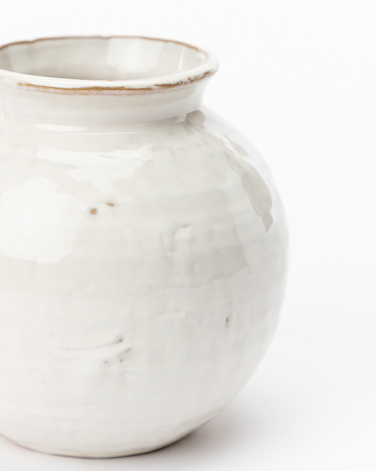 A close-up of the Rounded Ceramic Vase with distressed glaze, glossy textured surface, and a slightly flared rim featuring subtle brown accents—perfect for home decor. Set against a white background.