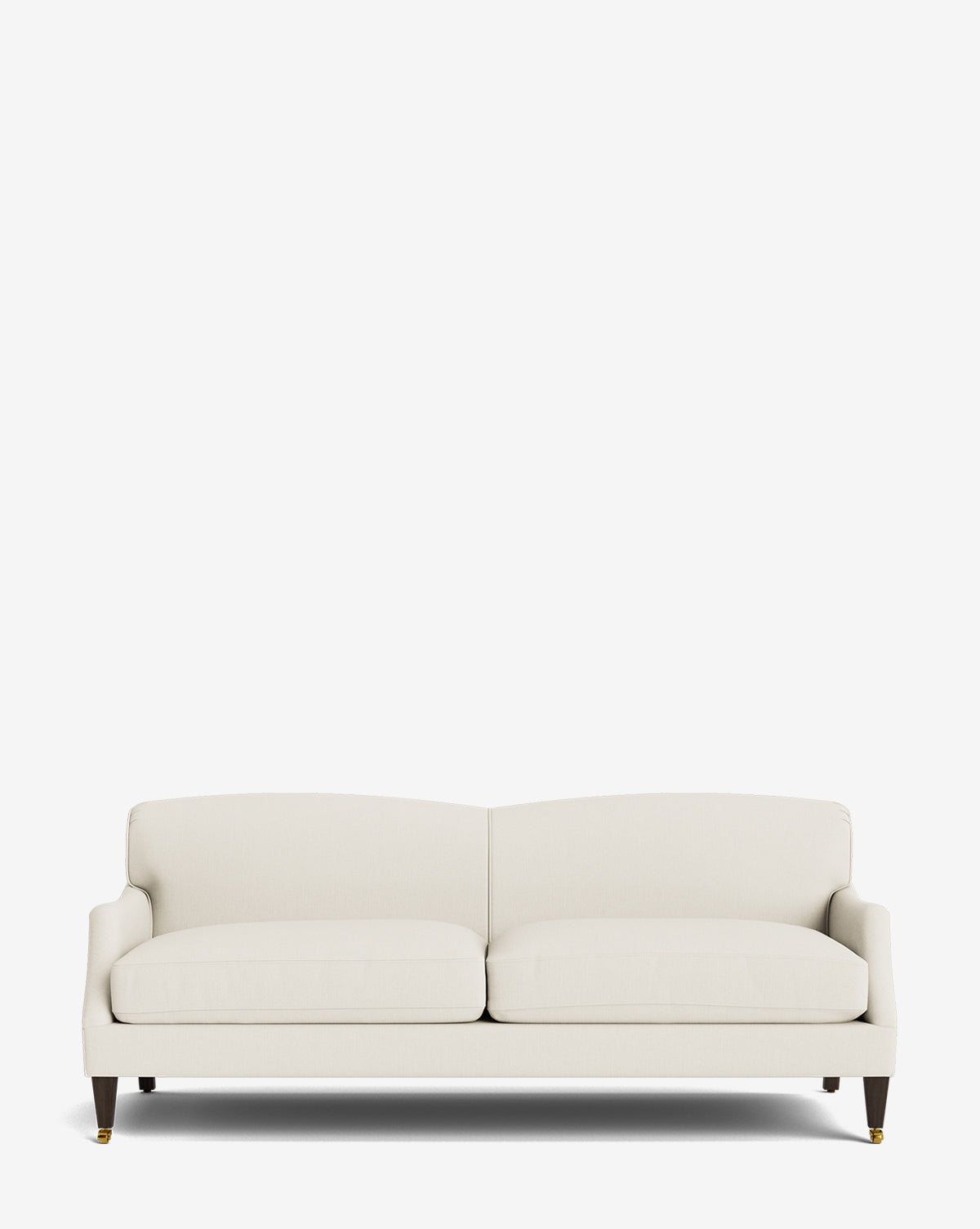 The Rowley Sofa 85 is a modern, cream-upholstered, hand-crafted sofa featuring two seat cushions, a low backrest, and dark wood legs with brass caster wheels, displayed against a plain white background by McGee & Co.