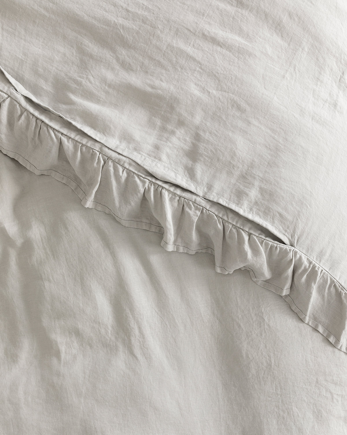 Close-up of the Ruffle Linen Duvet Cover in light gray, made from 100% linen. The soft, slightly wrinkled fabric offers a cozy and relaxed appearance.