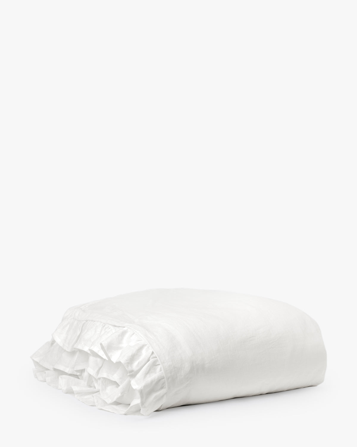 The Ruffle White Linen Duvet Cover, neatly folded with elegant ruffled edges, is displayed against a plain white background.