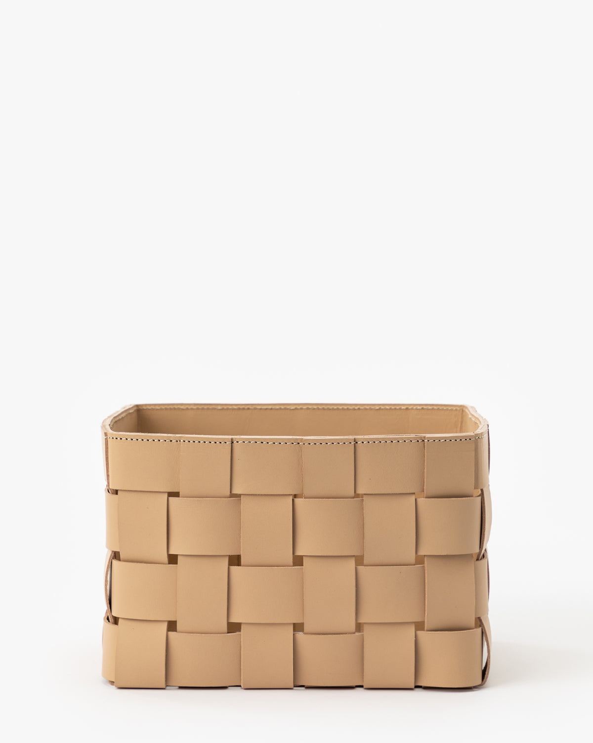 The Rupert Leather Bin is a rectangular beige bin made from wide, flat strips of woven leather, perfect for adding style to any home office. Shown against a plain white background.