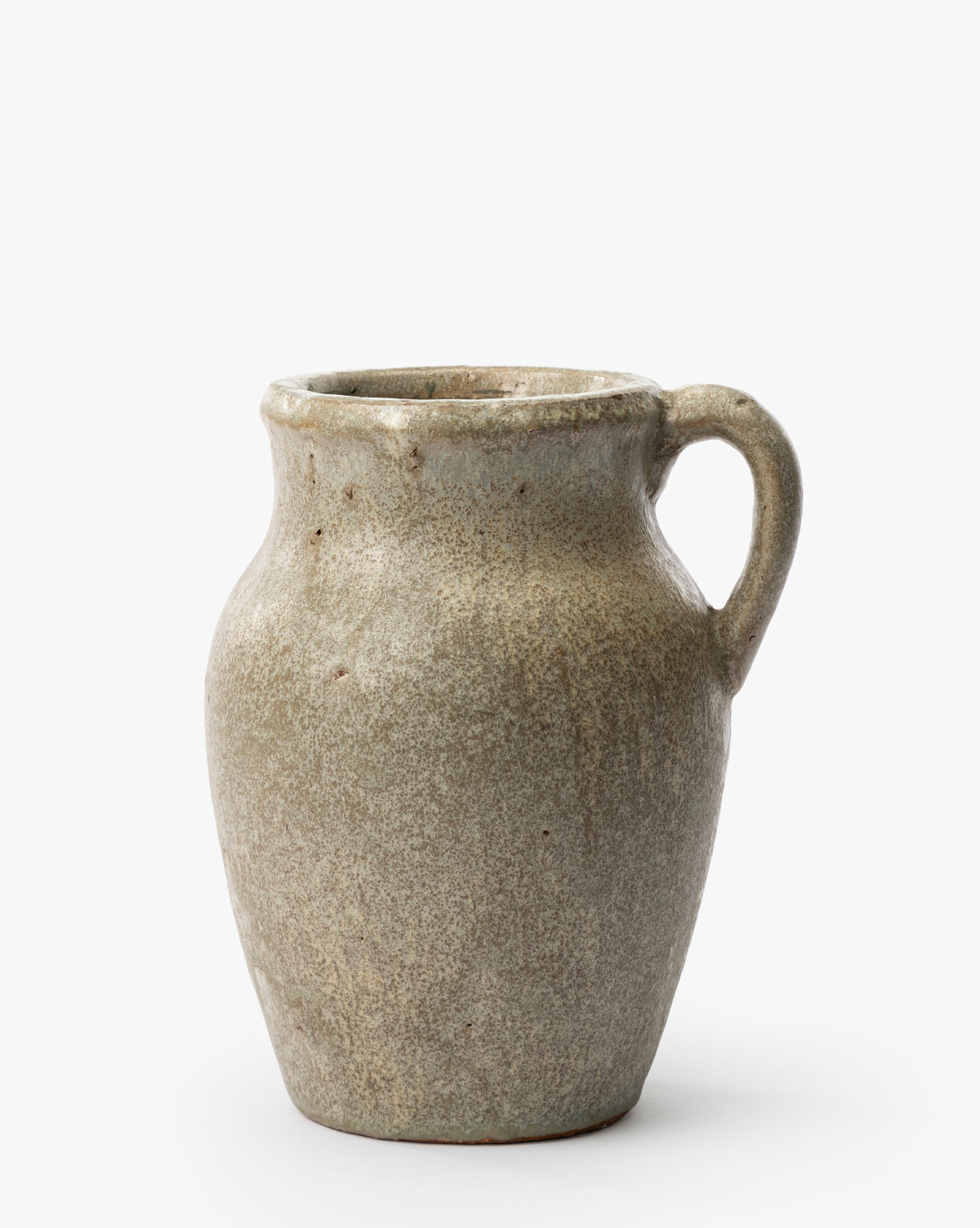 The Sabine Pitcher Vase is a rustic, glazed ceramic piece with a wide body, narrow neck, and single handle. Its earthy mottled gray-brown finish and handmade look stand out against a plain white background, by McGee & Co.