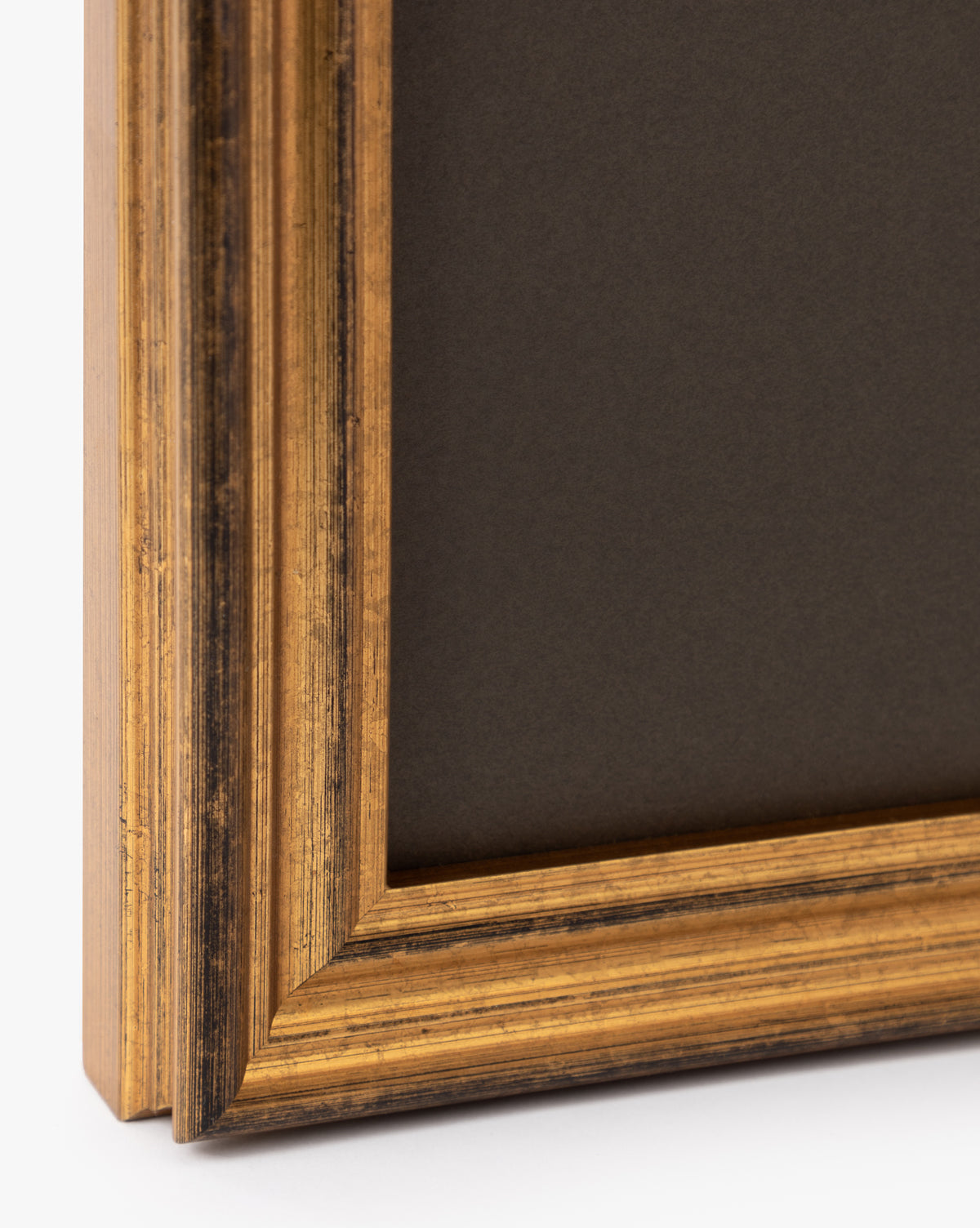Close-up of an antique gold frame corner with textured grooves and a black background, ideal for displaying the Sage Shores II giclee print.