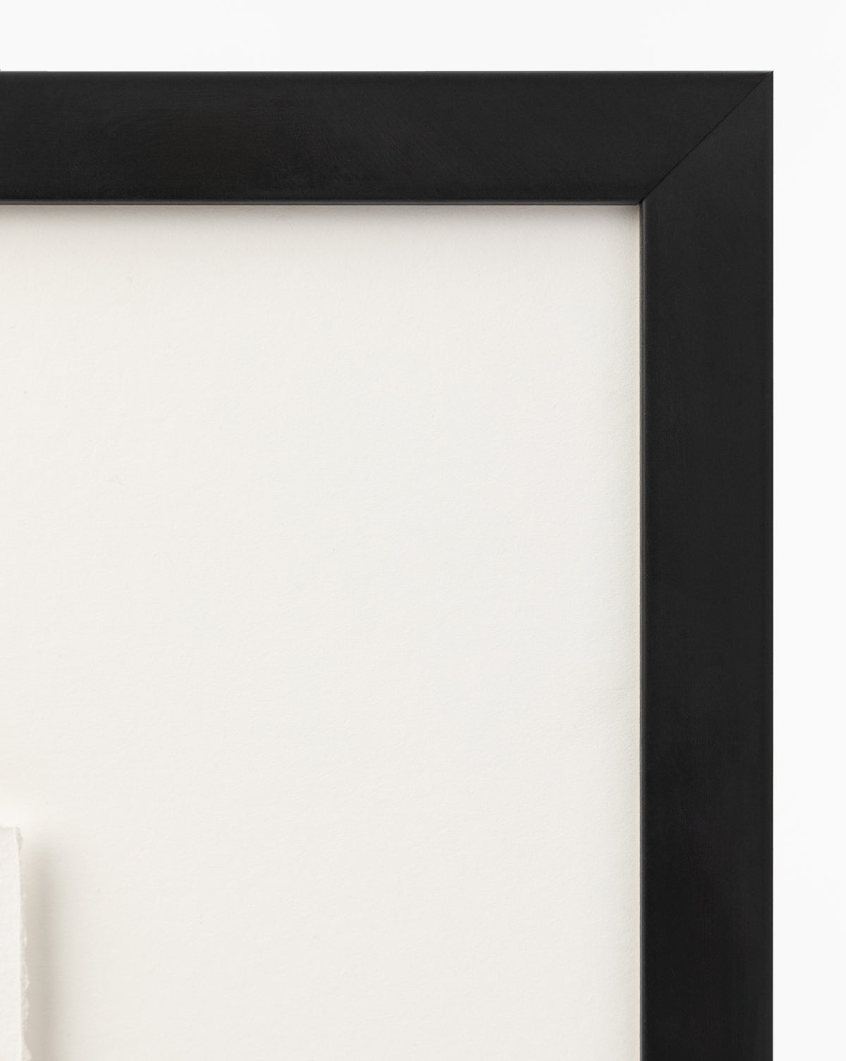 Close-up of the top right corner of a black wood frame with a white mat, shown against a plain white wall—ideal for displaying Sail Away small ships art or watercolor wall art, by McGee & Co.