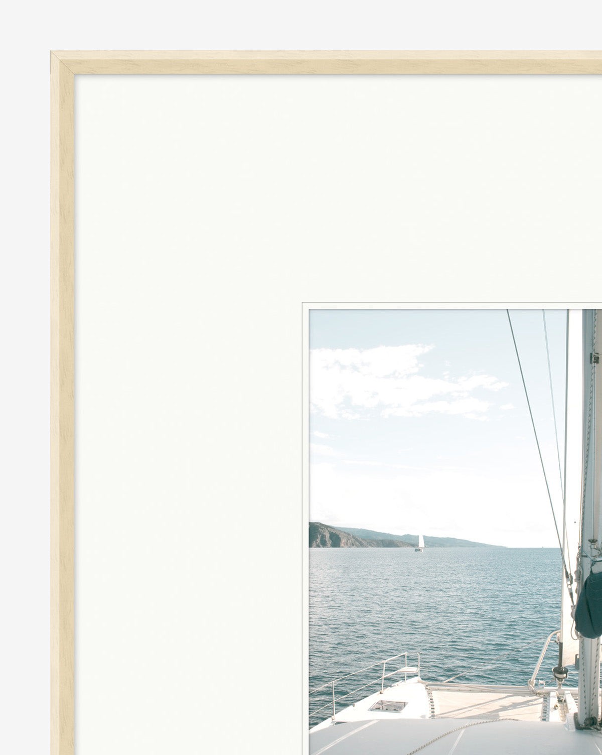 Sailboat Perspective is a decorative wall art photo in a pickled white frame, featuring an off-center sailboat on calm blue water with a distant coastline and ample white matting, under a clear blue sky.