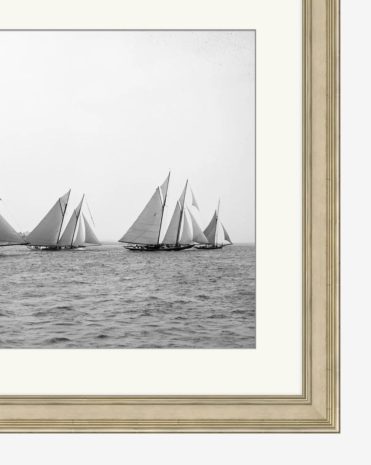 Sailing No. 3: A black and white photo of sailboats racing on the ocean, captured from afar and presented as a gallery-quality giclee print in a beige and white matted frame.