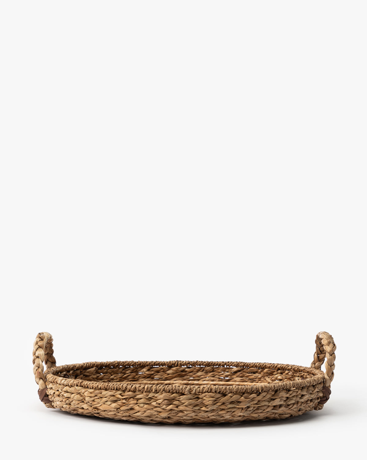 The Salter Woven Tray is a round, flat seagrass tray featuring two looped handles on each side, shown against a plain white background, by McGee & Co.