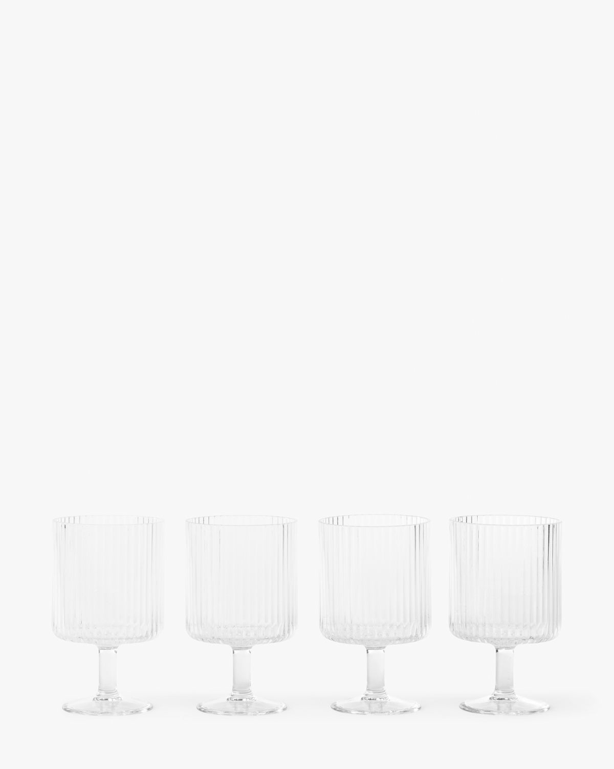 The Sanibel Acrylic Goblets (Set of 4) feature clear, ribbed designs and short stems, arranged in a row against a white background—ideal for outdoor table settings with their elegant, durable style.