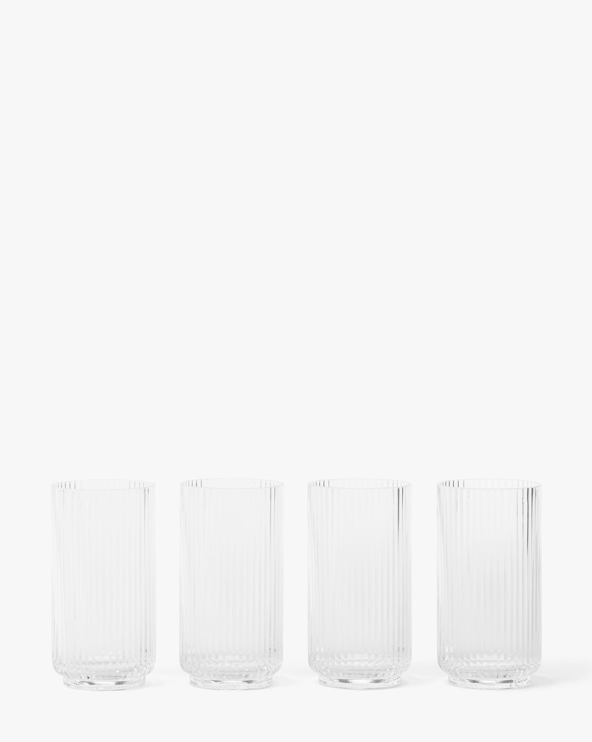 The Sanibel Acrylic Highball Drinking Glasses (Set of 4) feature vertical ribbed patterns and are arranged in a row against a plain white background, making them perfect for elegant outdoor table settings, by McGee & Co.
