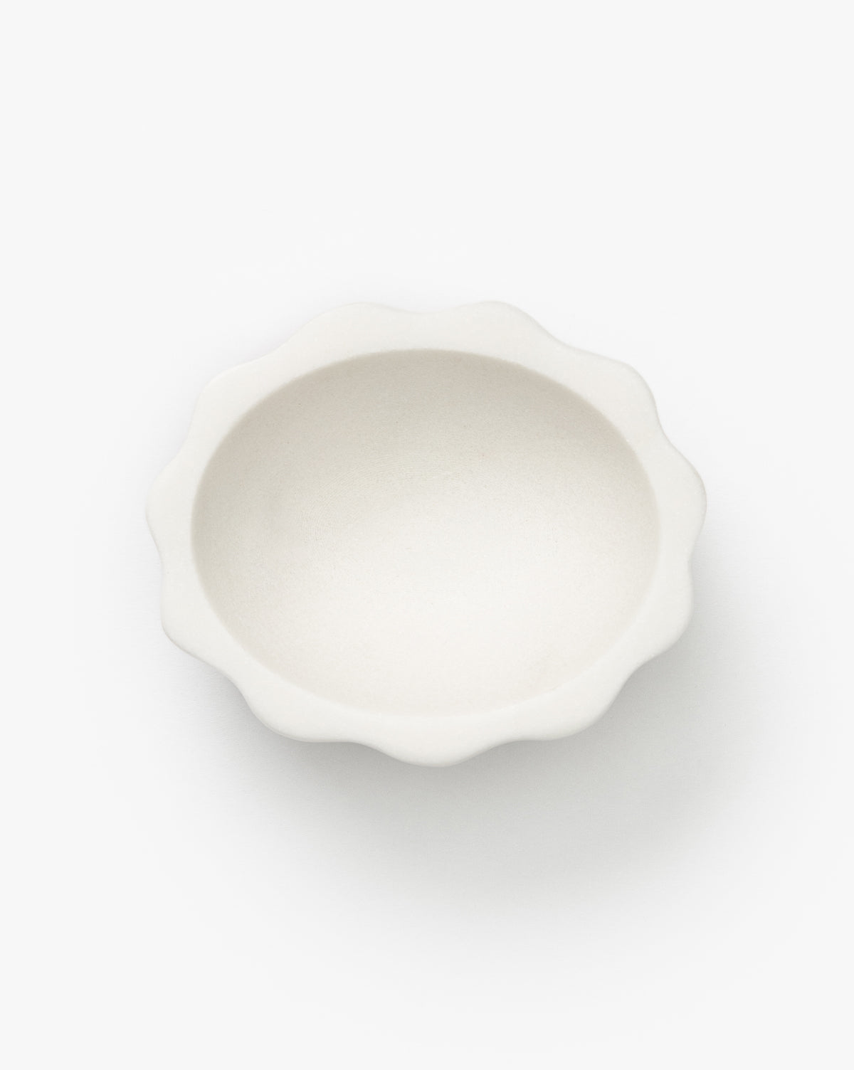 The Scalloped Marble Bowl is a small, round, white bowl with wavy, scalloped edges, displayed against a plain white background by McGee & Co.