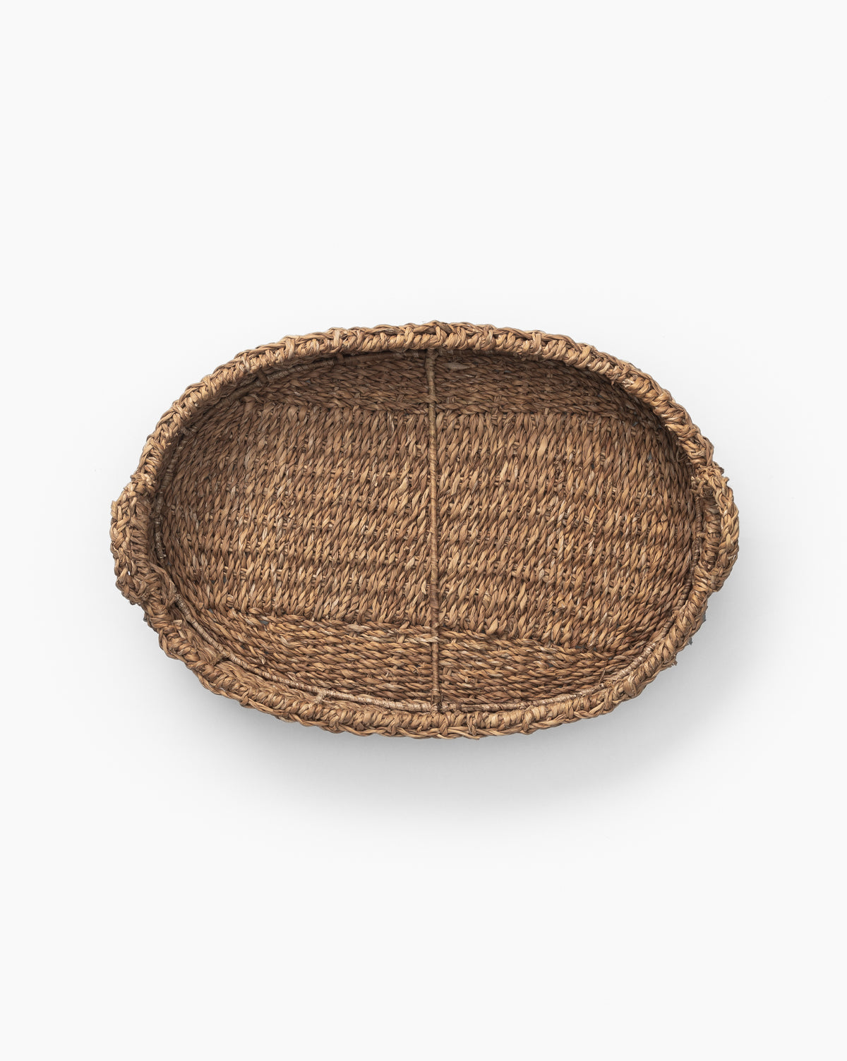 The Seagrass Oval Tray features two small handles and natural details, shown from above on a white background—a stylish, versatile decorative tray for any space.