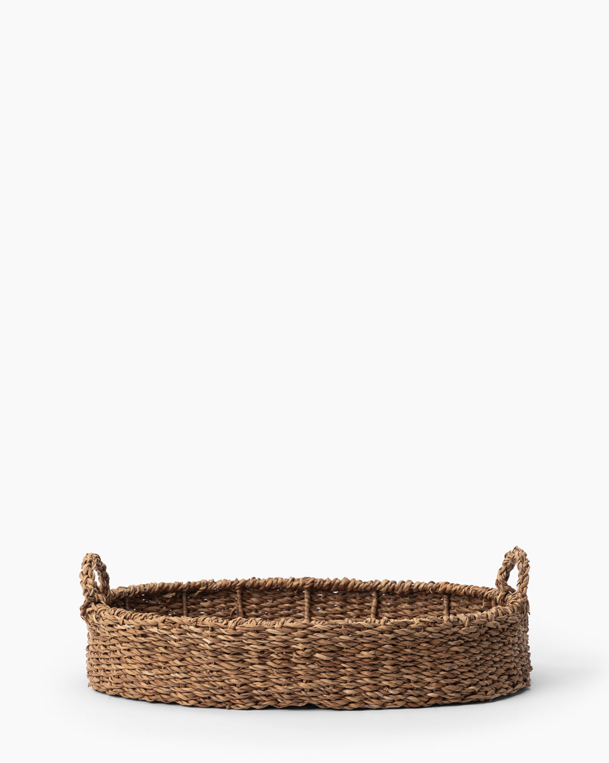 The Seagrass Oval Tray features two small handles and a natural woven design, displayed on a plain white background.