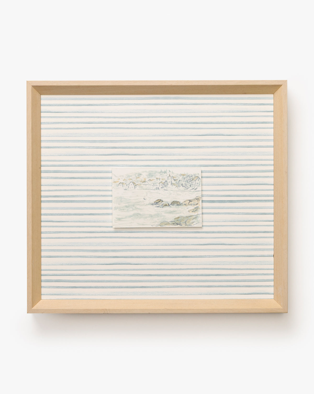 Seaside Village features a subtle landscape centered on evenly spaced blue lines, evoking coastal charm within a light wooden frame and set against a crisp white backdrop, by McGee & Co.