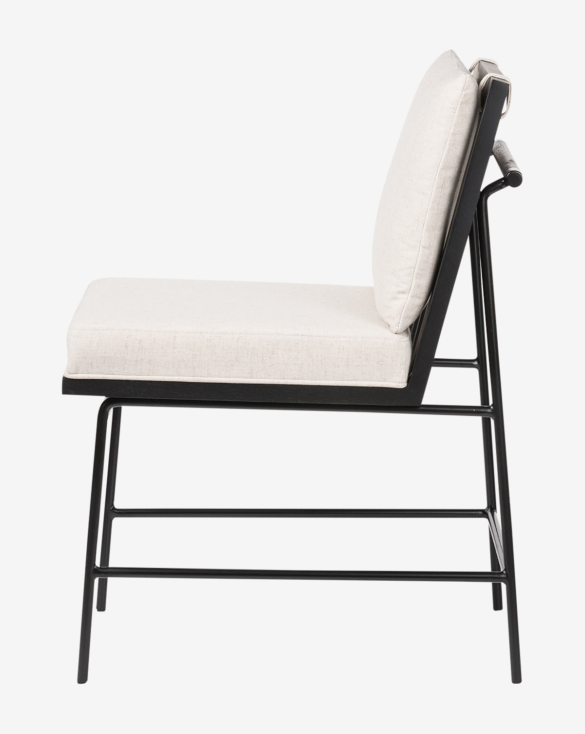 Side view of the Selas Dining Chair highlighting its black iron frame, light beige high-performance fabric cushions, minimalistic design, clean lines, and subtly angled backrest by McGee & Co.
