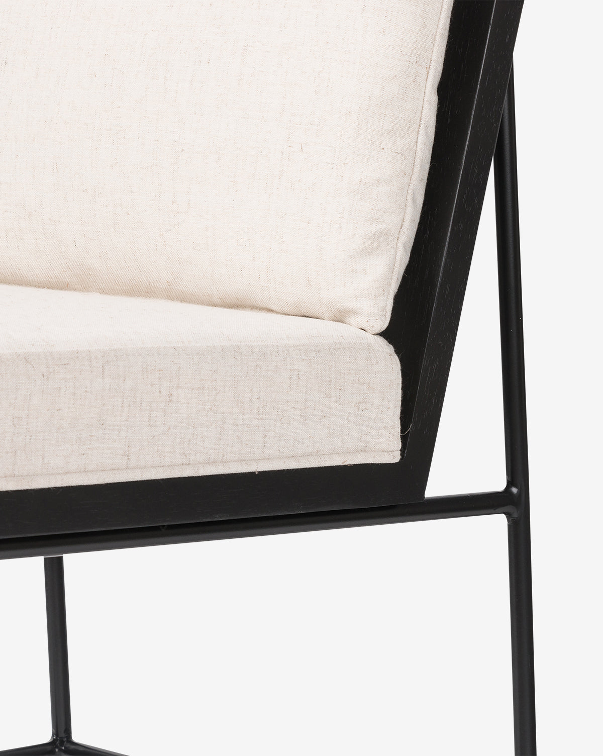 Close-up of the Selas Dining Chair, highlighting its minimalist black iron frame and light beige high-performance fabric cushions on the seat and backrest for a contemporary look, by McGee & Co.