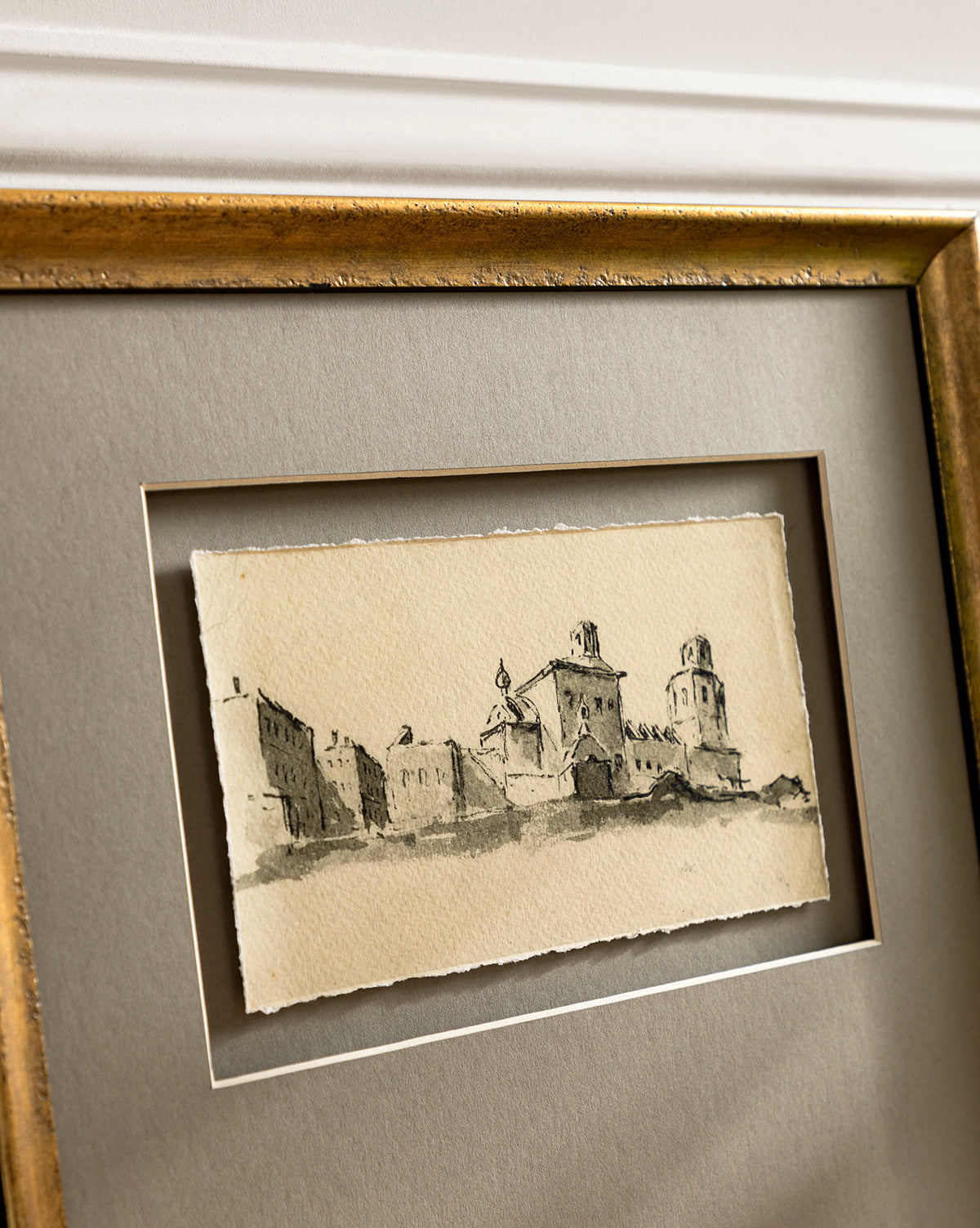 Sepia City is a gallery-quality framed sketch of historic buildings with towers, set on a taupe mat in a gold frame. This romantic town scene is printed on textured paper with uneven edges for an elegant, vintage look.