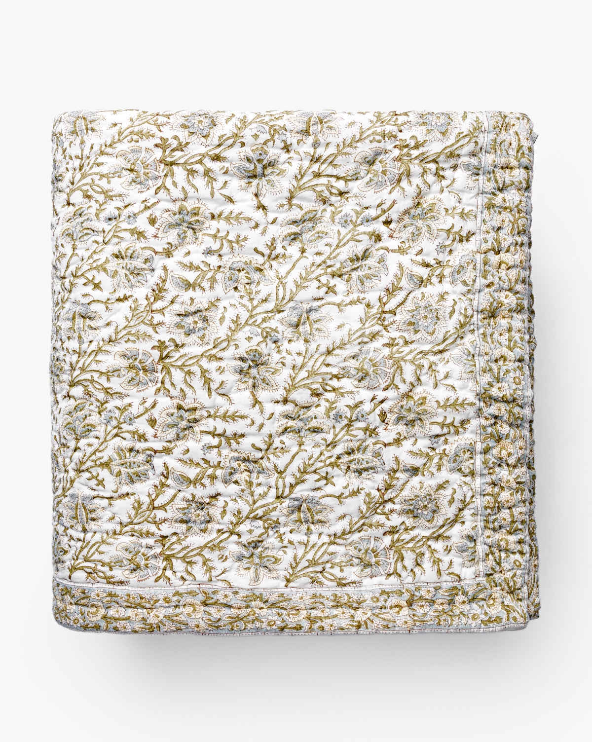 The Seton Kids Quilt by Renuka Inc. features a detailed green and gold floral pattern on a white background, elaborate stitching, and a decorative border—McGee & Co.