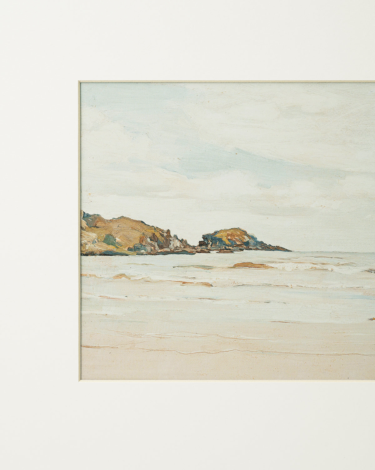 Shoreline Rocks is a painting of a calm coastal scene with gentle waves, sandy shore, and distant shoreline rocks under a pale cloudy sky, bordered by a white mat, by McGee & Co.