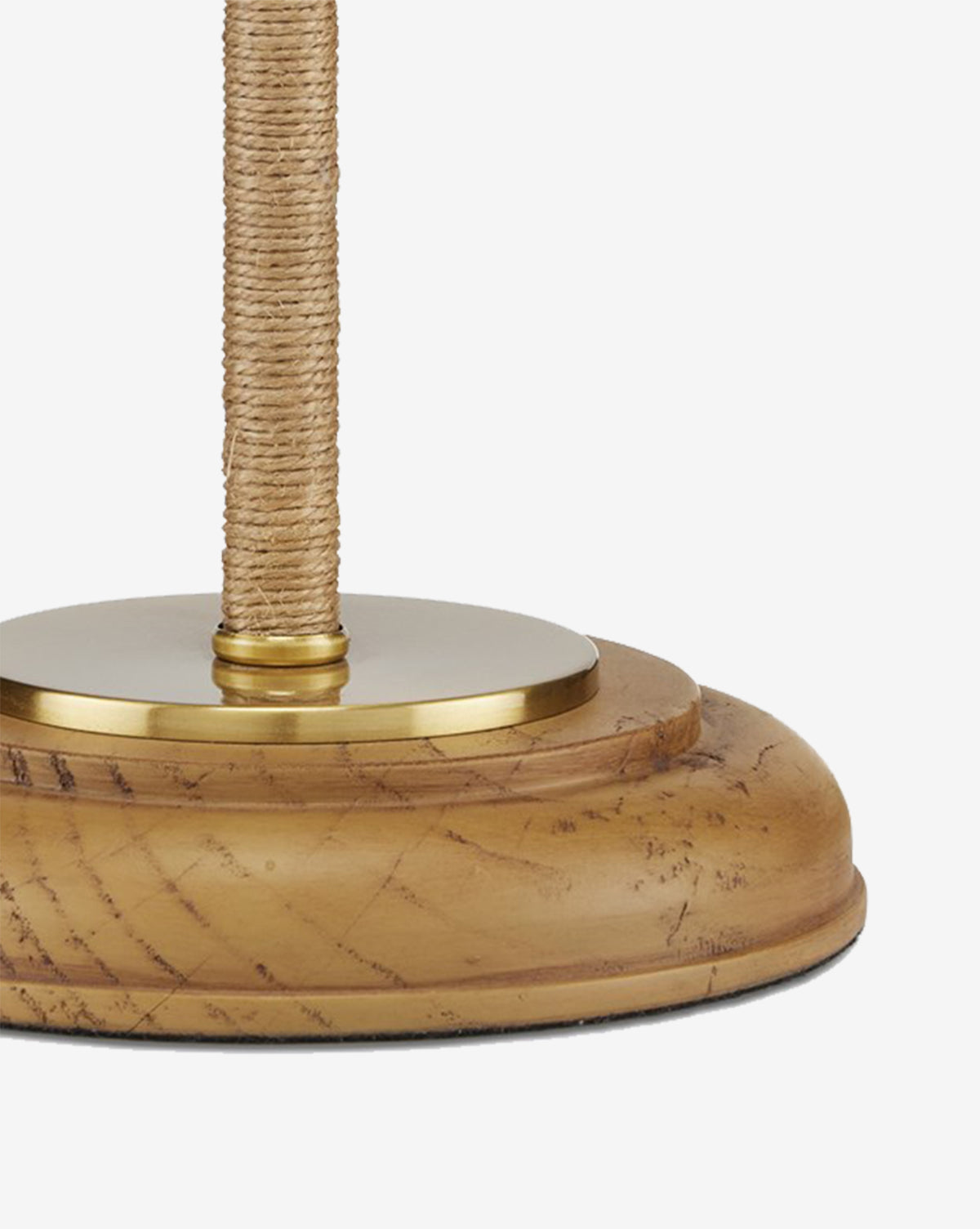 A close-up of the Sirocco Desk Lamp highlights its round wooden base with visible scratches and grain, an antique brass accent at the top, and a pole wrapped in natural rope, by McGee & Co.