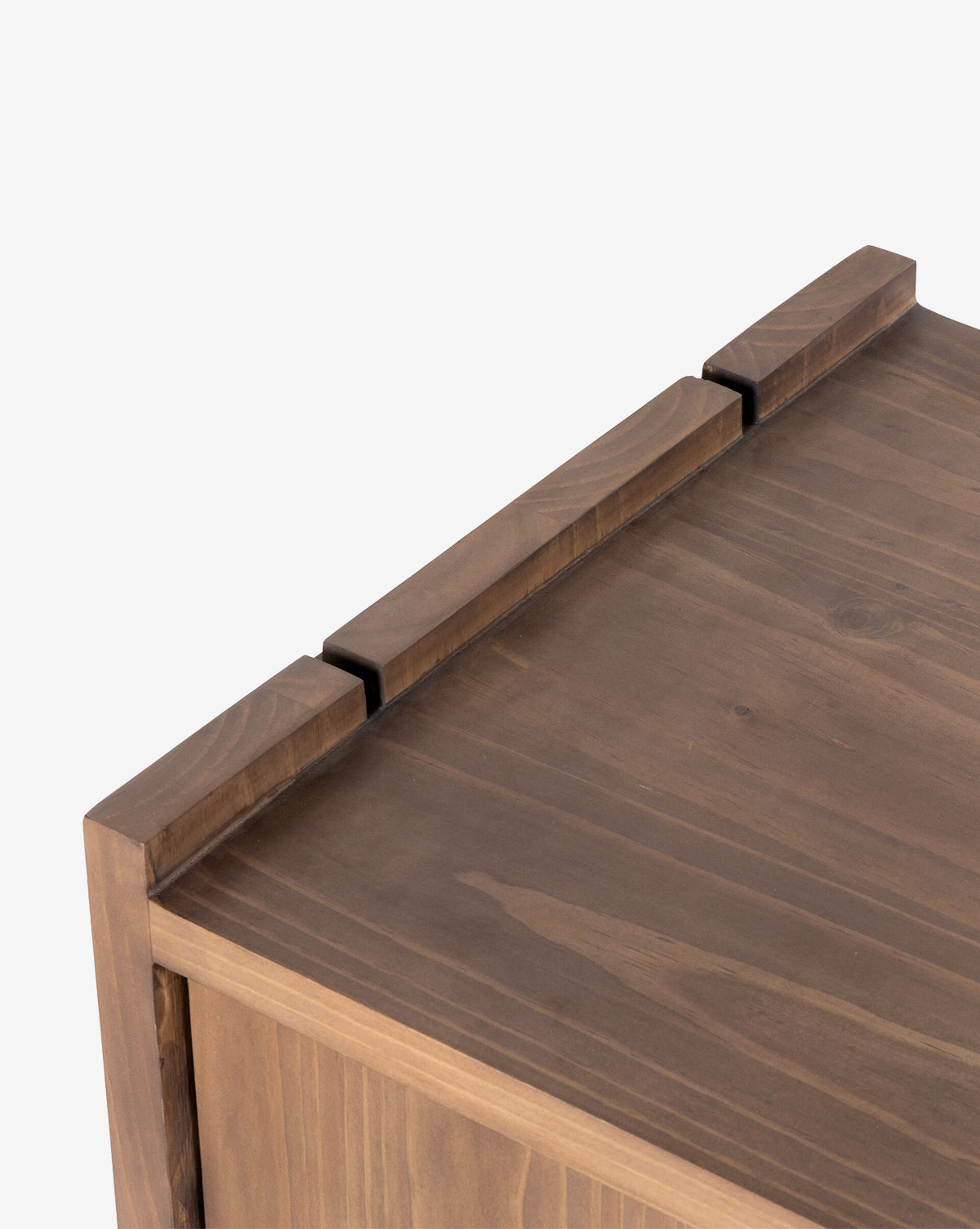 Close-up of the Sloane Sideboard’s corner, highlighting its solid pine build, smooth finish, visible natural wood grain, and minimalist design with three raised rectangular sections along the edge, by McGee & Co.