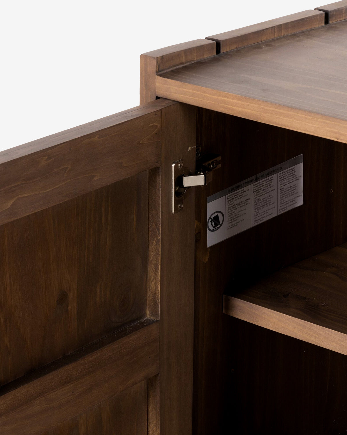 Close-up of the Sloane Sideboard’s interior with an open door, highlighting the metal hinge, interior shelf, and a label featuring text and symbols affixed to the side by McGee & Co.