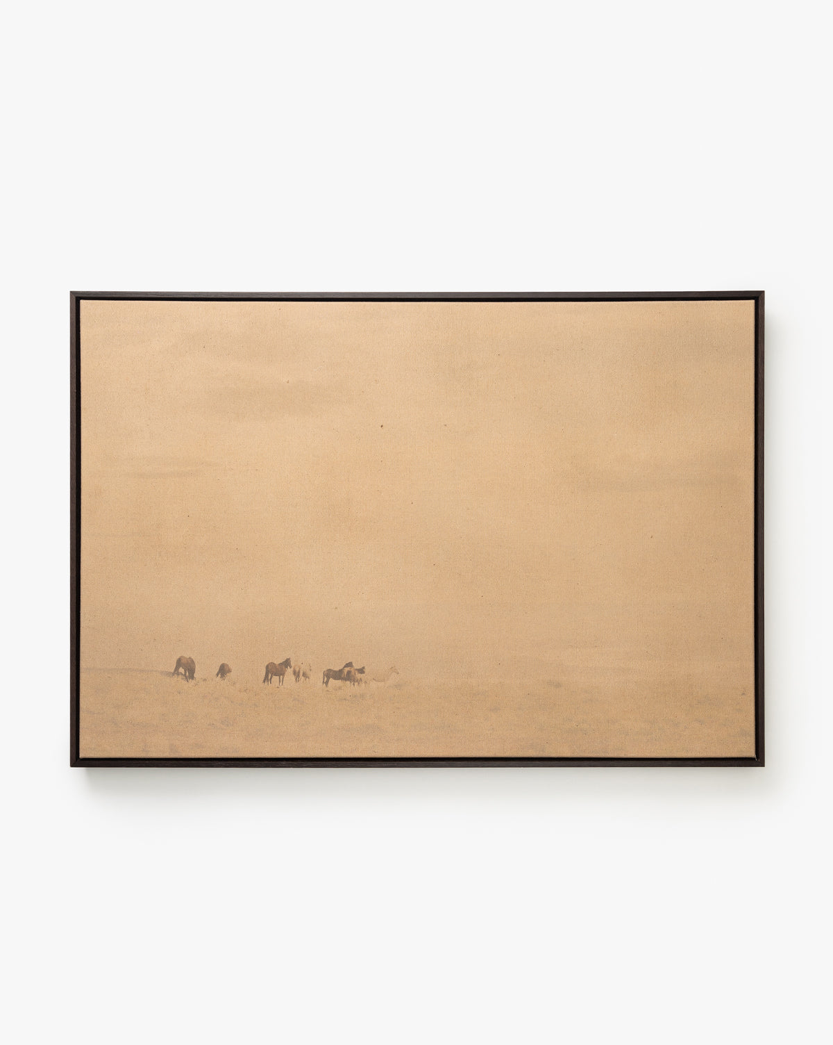 Smokey Pasture is a minimalist country landscape wall art, featuring a tan background with subtle outlines of grazing animals in the lower left, evoking feelings of emptiness and vast open space, by McGee & Co.