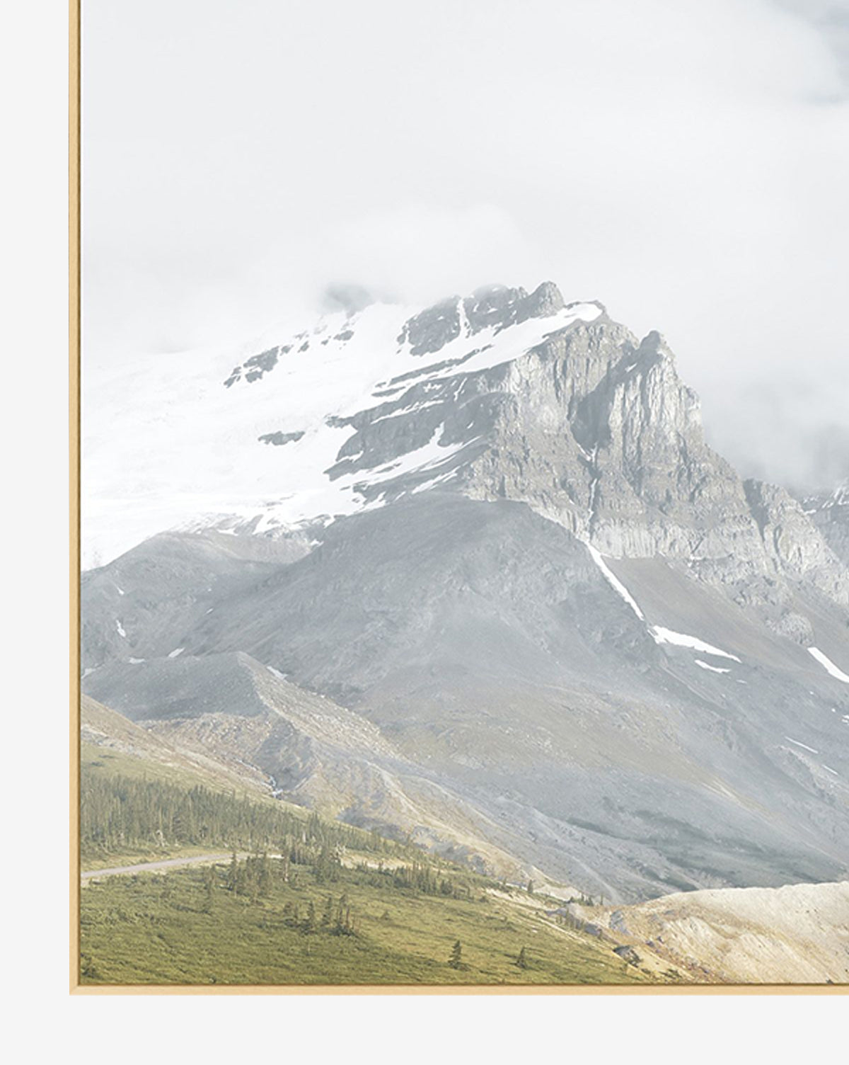 Snow Covered Peaks features a snowy mountain summit amid clouds, rugged slopes, and lush green grass in the foreground. Visible is a slim, light frame on the left—perfect wall art giclee print for nature enthusiasts.