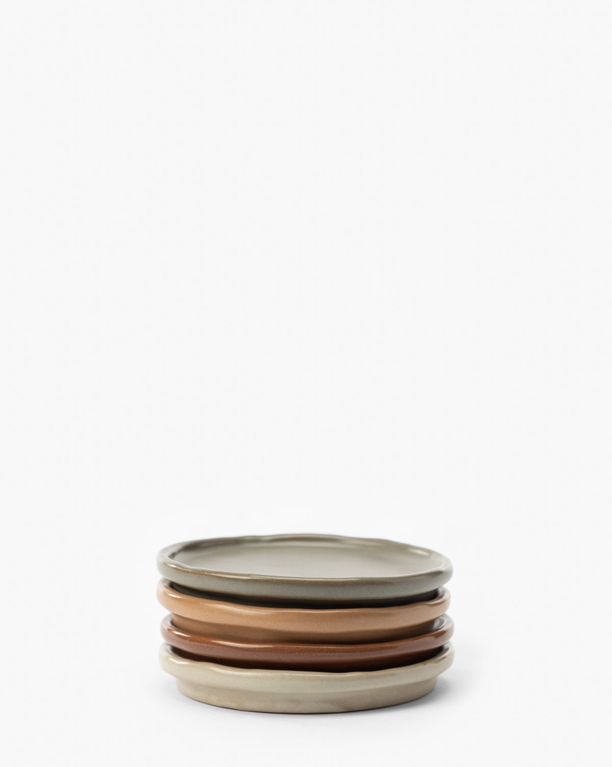 A set of four ceramic plates in beige, brown, and taupe pairs beautifully with Speckled Ceramic Coasters (Set of 4), creating a versatile tabletop display against a white background, by McGee & Co.