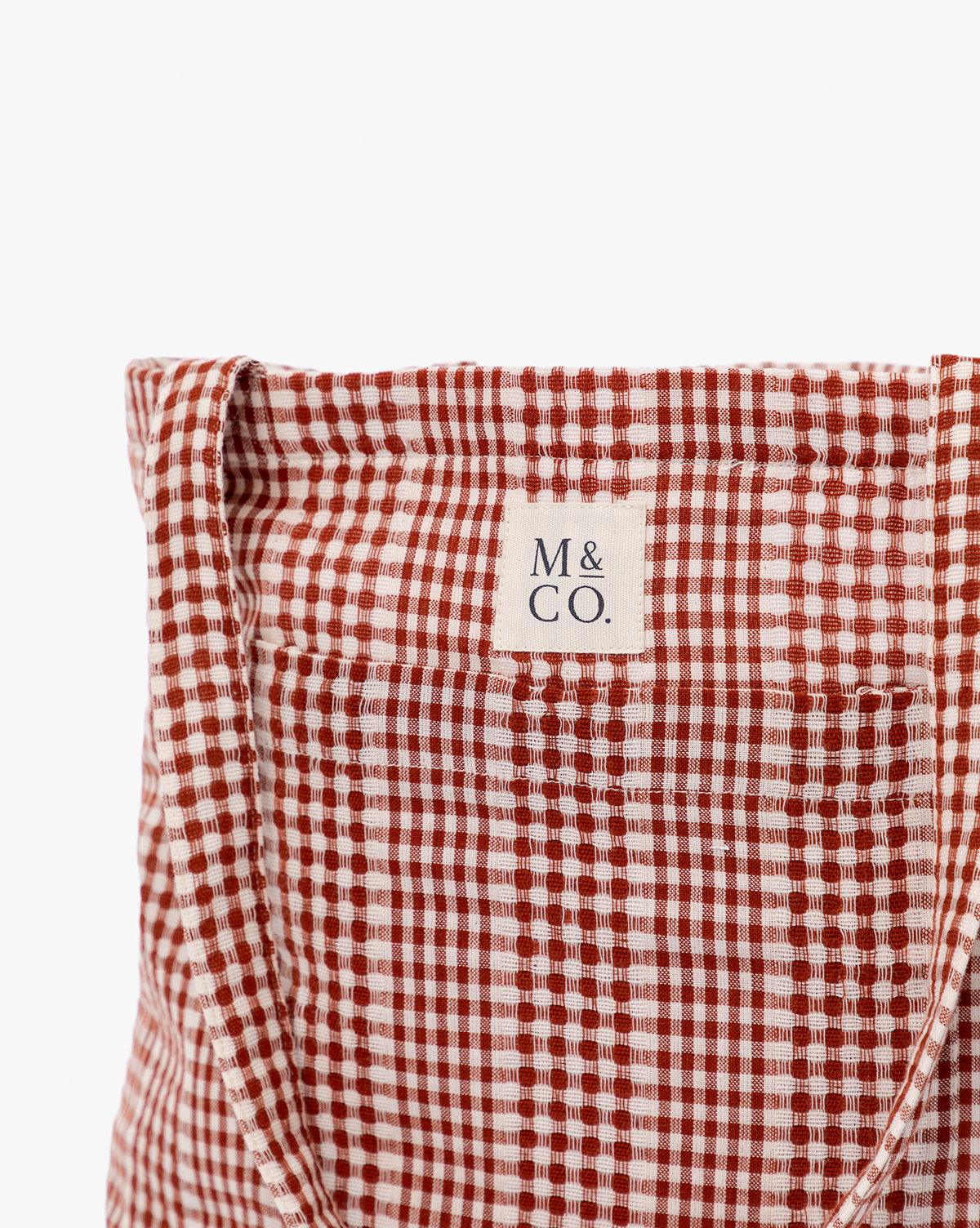 Close-up of the Spencer Tote Bag in red and white gingham with a visible “M & CO.” label stitched on the upper center, ideal for casual outings by McGee & Co.
