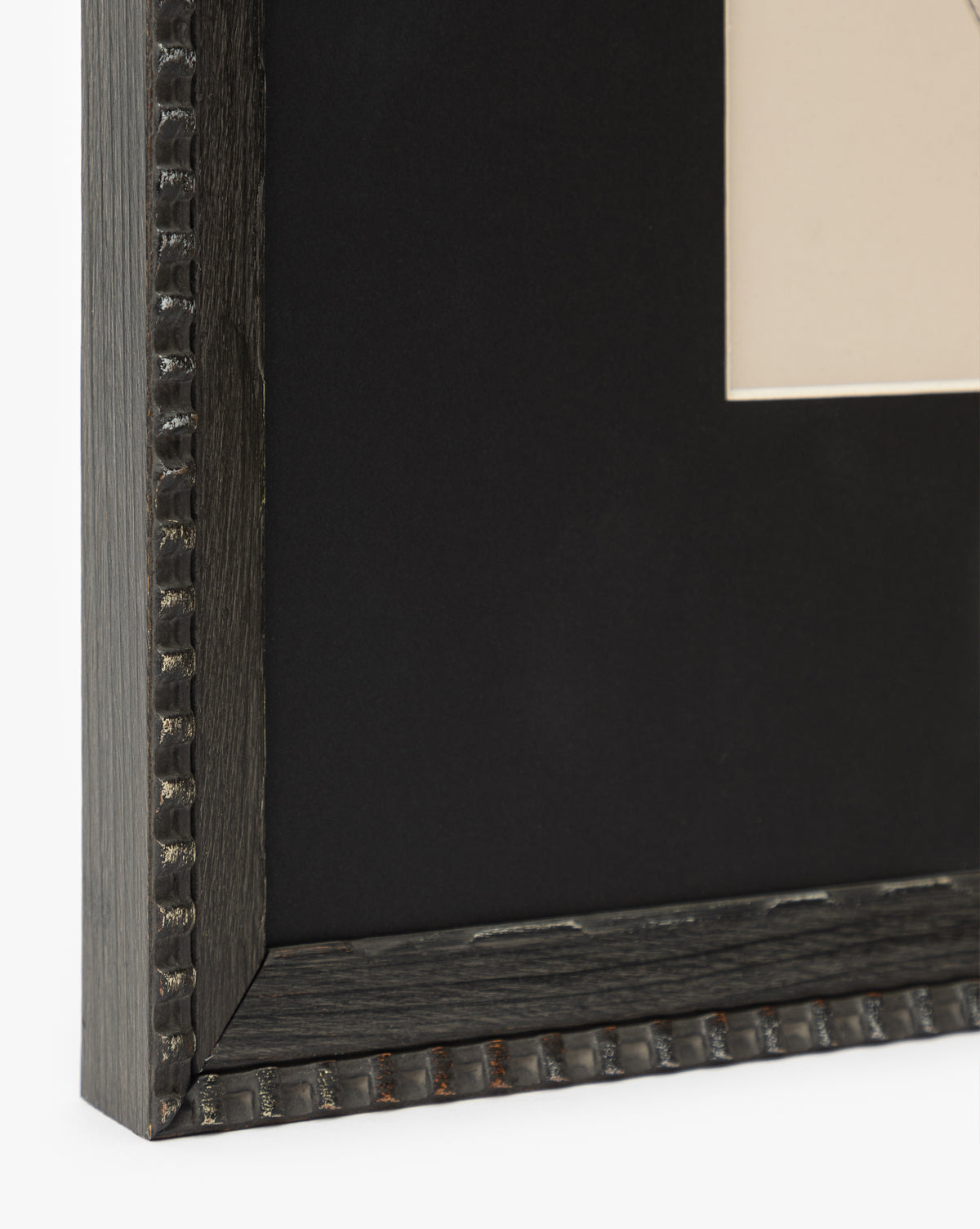 Close-up of the corner of the Spirit frame in black, featuring a textured beaded edge. Ideal for wall art, it displays a black mat and beige horse portrait, with only a small part of the artwork seen, by McGee & Co.