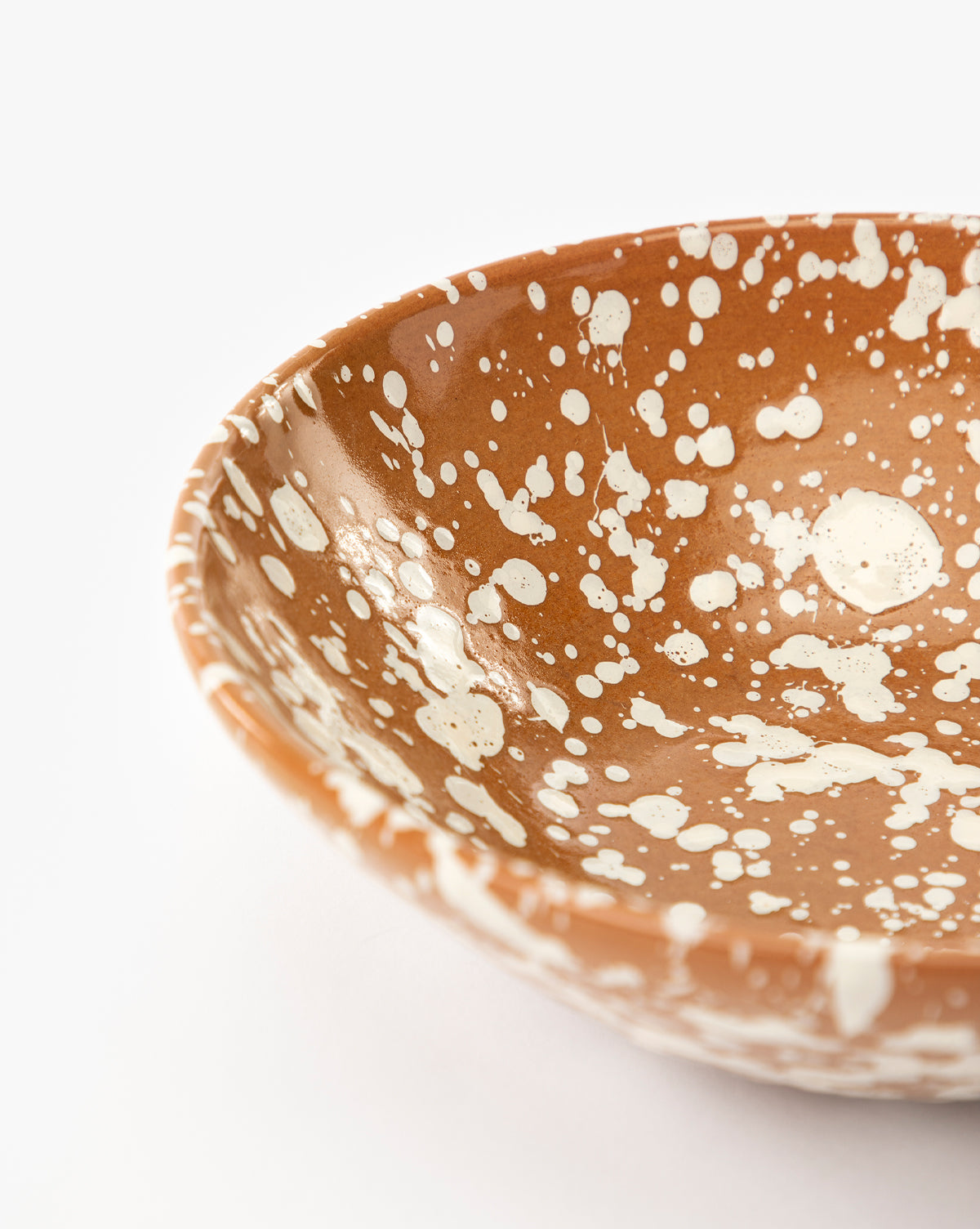 Close-up of the Splatter Large Bowl, handcrafted brown ceramic with irregular white splatter and spot patterns, set against a plain white background, by McGee & Co.