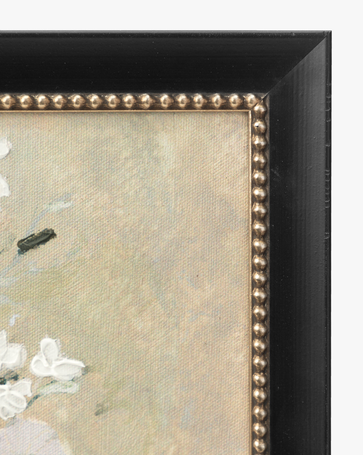 Close-up of the top right corner of the framed giclee print Spring Fresh Cuts, featuring a black wooden frame with gold beaded trim and part of the light-colored, textured canvas adorned with white floral details.