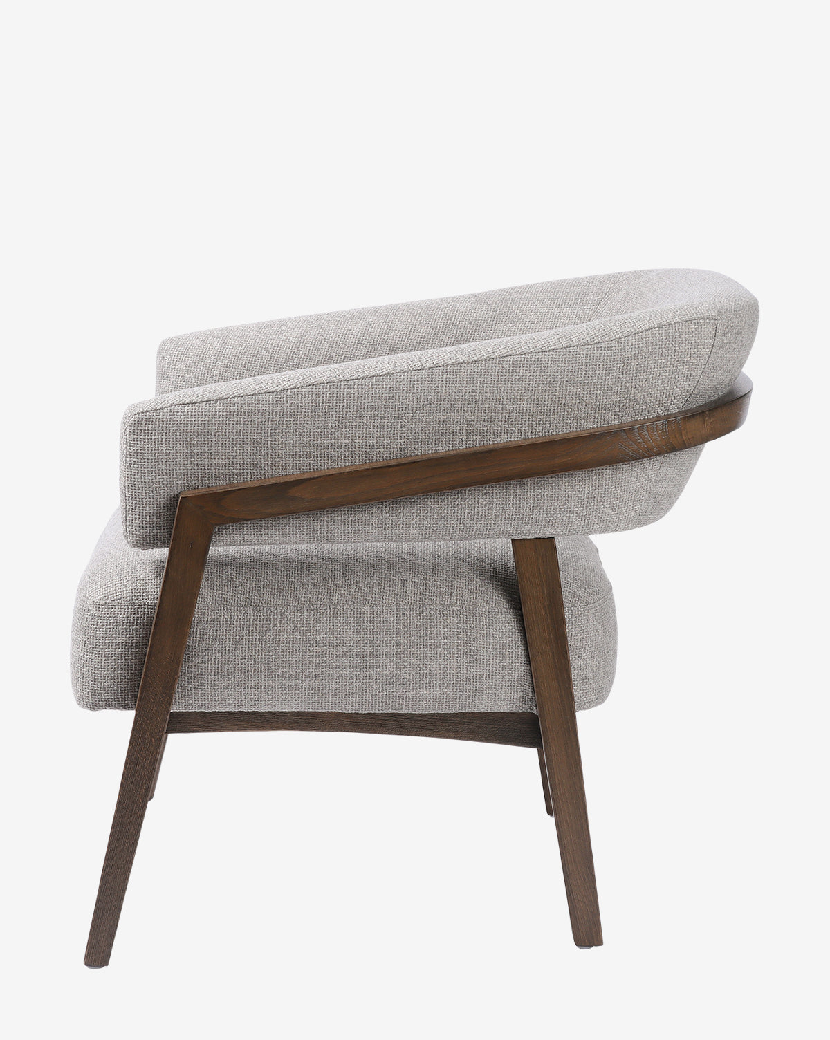 Side view of the Stanley Lounge Chair, a modern seat with light gray cushions and a wooden frame, featuring angled legs and curved armrests, by McGee & Co.