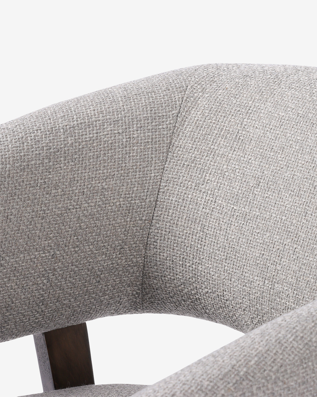 Close-up of the Stanley Lounge Chair in light gray textured upholstery, featuring a curved backrest, partial seat view, and wooden support. Set against a plain white background for a modern, contemporary look, by McGee & Co.