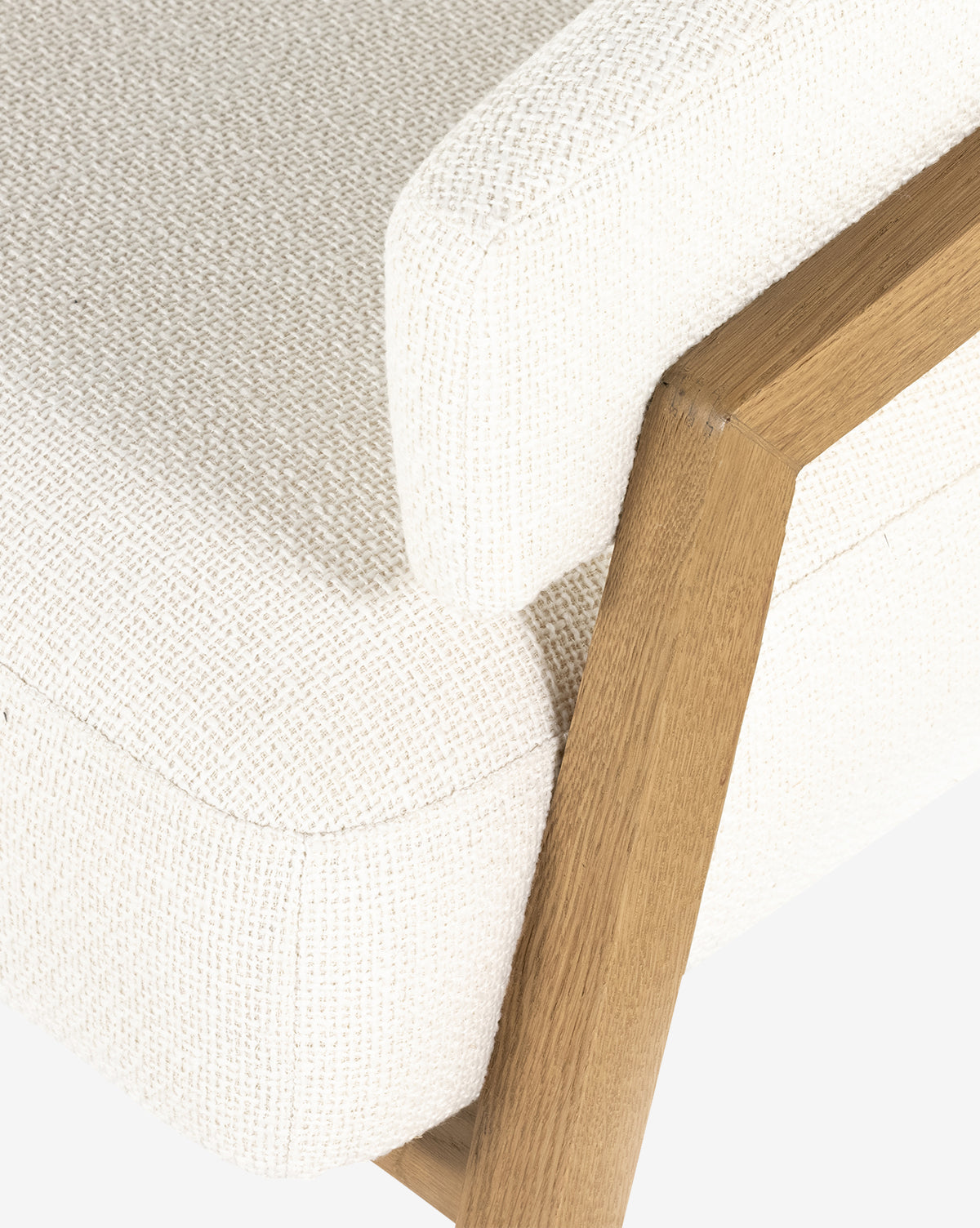 Close-up of the Stanley Lounge Chair, featuring a contemporary design with a textured off-white cushion and light wood frame, focusing on the armrest and seat against a plain background, by McGee & Co.