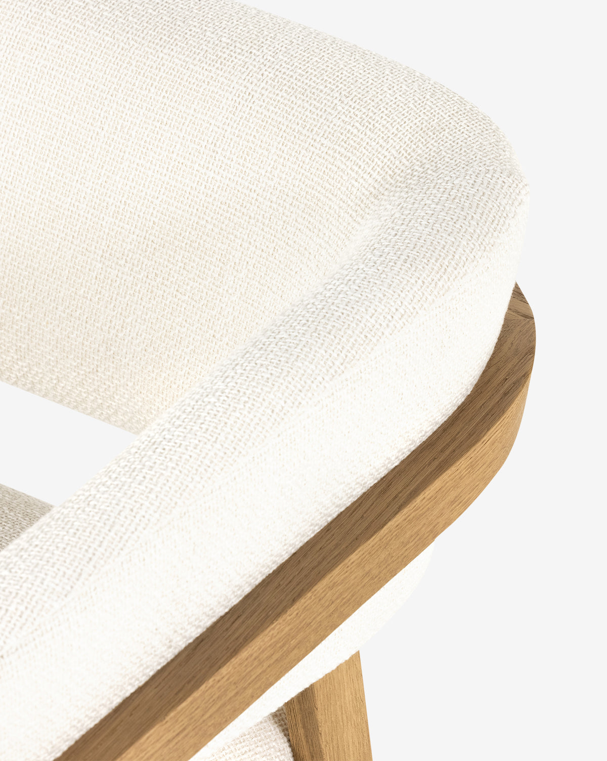 Close-up of the Stanley Lounge Chair, showcasing its textured white upholstery and smooth light wood frame and legs, reflecting a modern aesthetic against a plain white background, by McGee & Co.