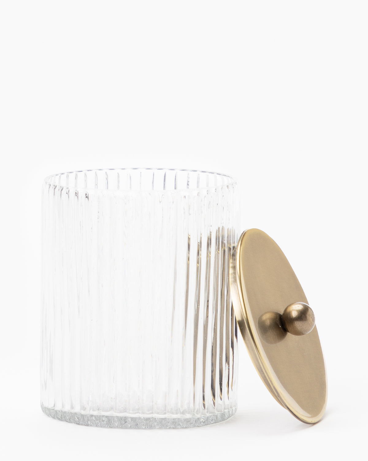 A clear, ribbed blown glass jar from the Stein Glass Collection with a round brass-finish lid and two small handles—ideal for displaying on any bathroom countertop.
