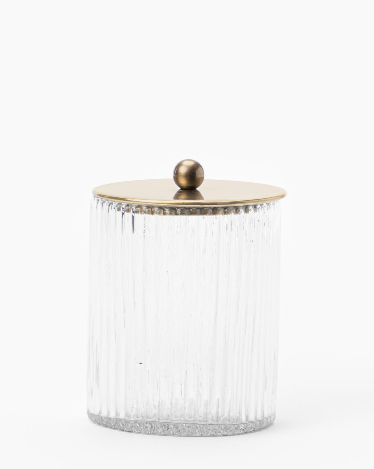 A clear blown glass jar with vertical ridges from the Stein Glass Collection, featuring a round brass lid with a knob—ideal for displaying on any bathroom countertop.
