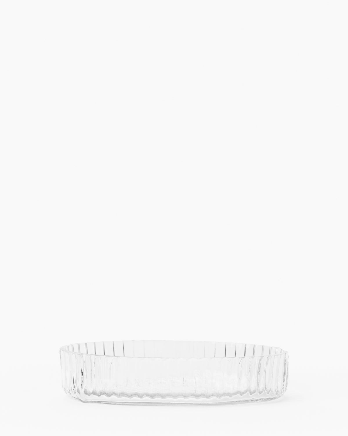 A clear, round tray with vertical ridged sides from the Stein Glass Collection is shown on a white background—ideal for organizing your bathroom countertop.