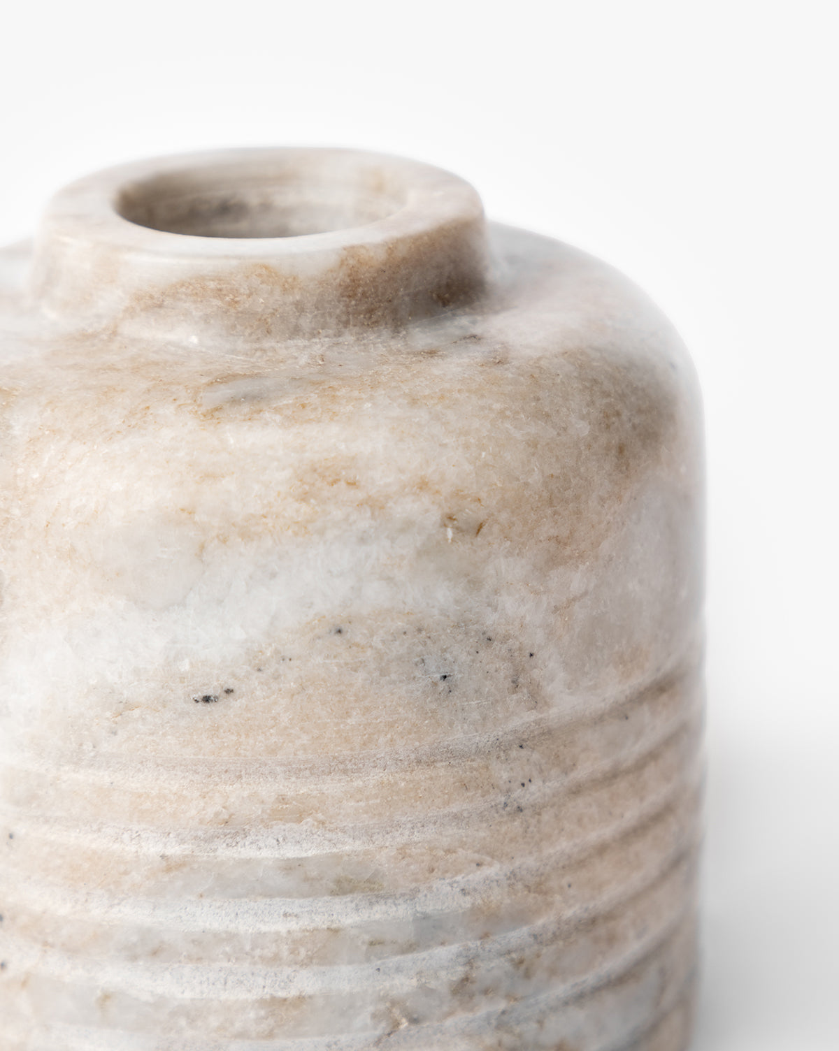 Close-up of the upper part of the Stinson Marble Bud Vase—a small, round beige and white vase with subtle veining and horizontal etched lines near the base—set against a plain white background, by McGee & Co.