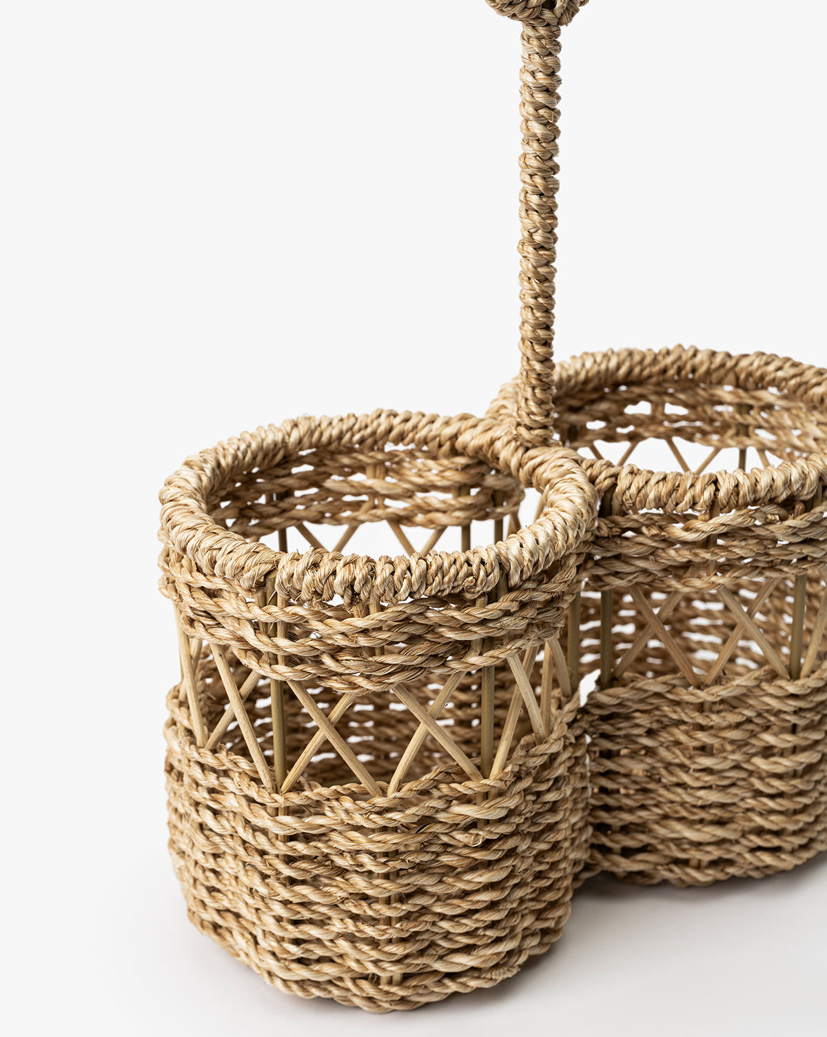Close-up of the Stokes Woven Caddy, a handwoven abaca wicker organizer with three cylindrical compartments, braided handle, and crisscross details—perfect for kitchen counters. Shown against a plain white background, by McGee & Co.