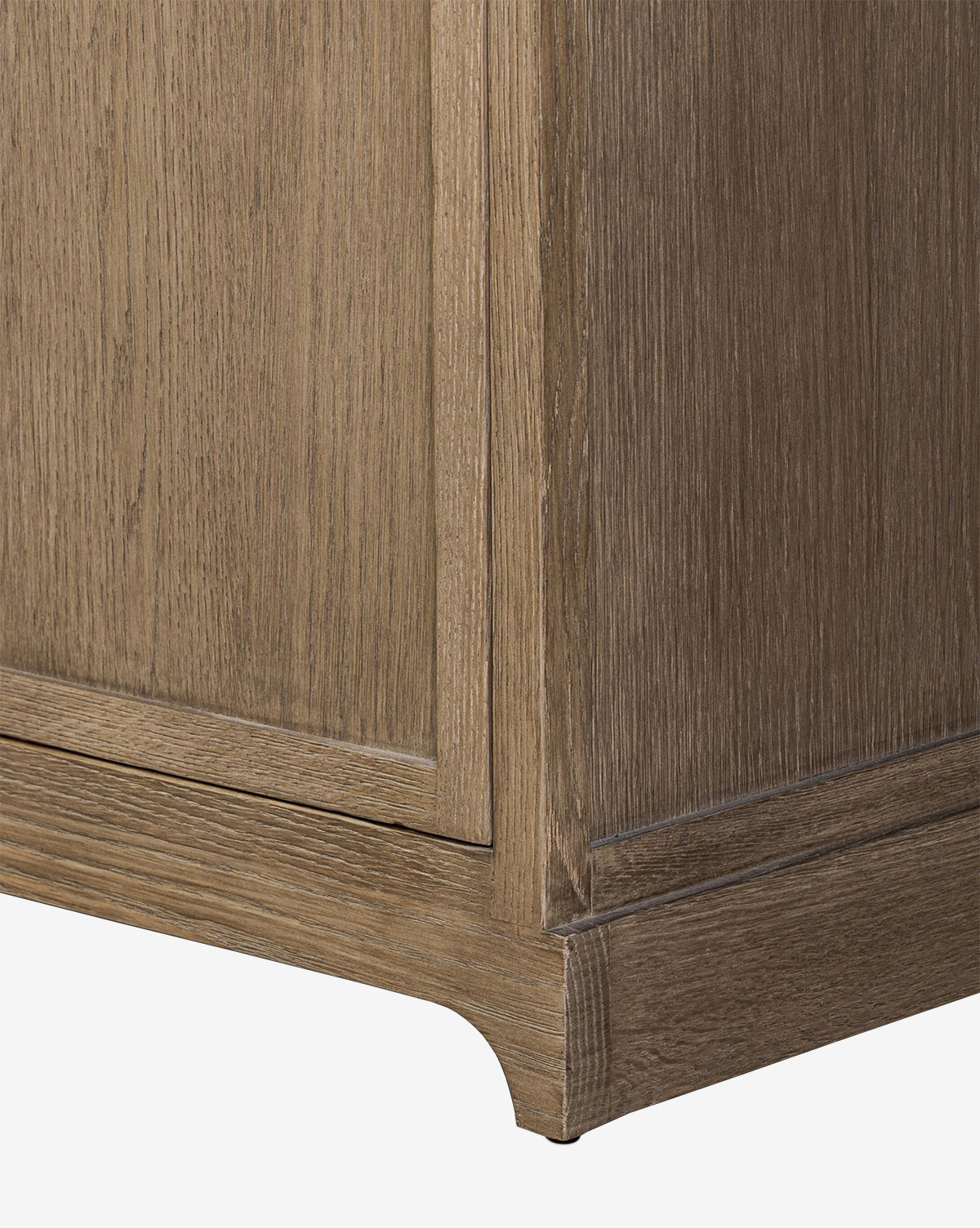 Close-up of the Stonington Oak Sideboard’s corner, showing its light brown, weathered washed oak finish and simple, classic base for a vintage-inspired look, by McGee & Co.
