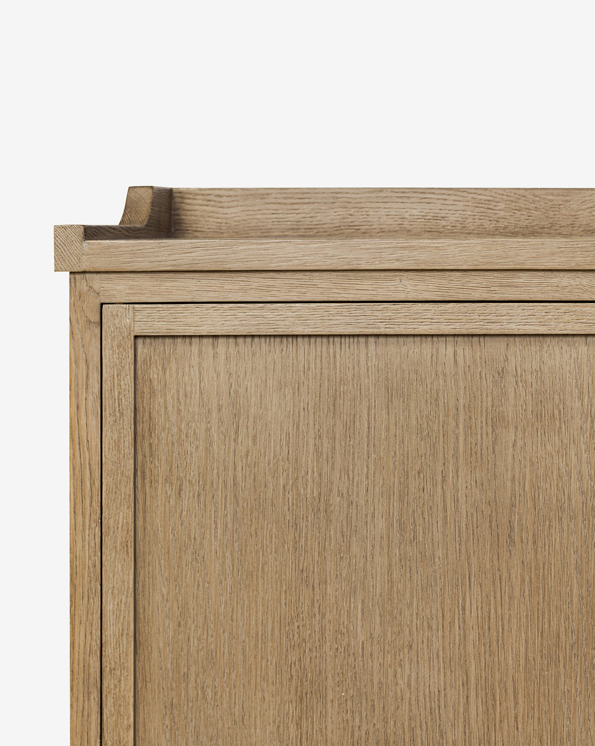 A close-up of the Stonington Oak Sideboards top corner highlights its light natural finish, clean lines, and simple modern design against a plain white background, by McGee & Co.