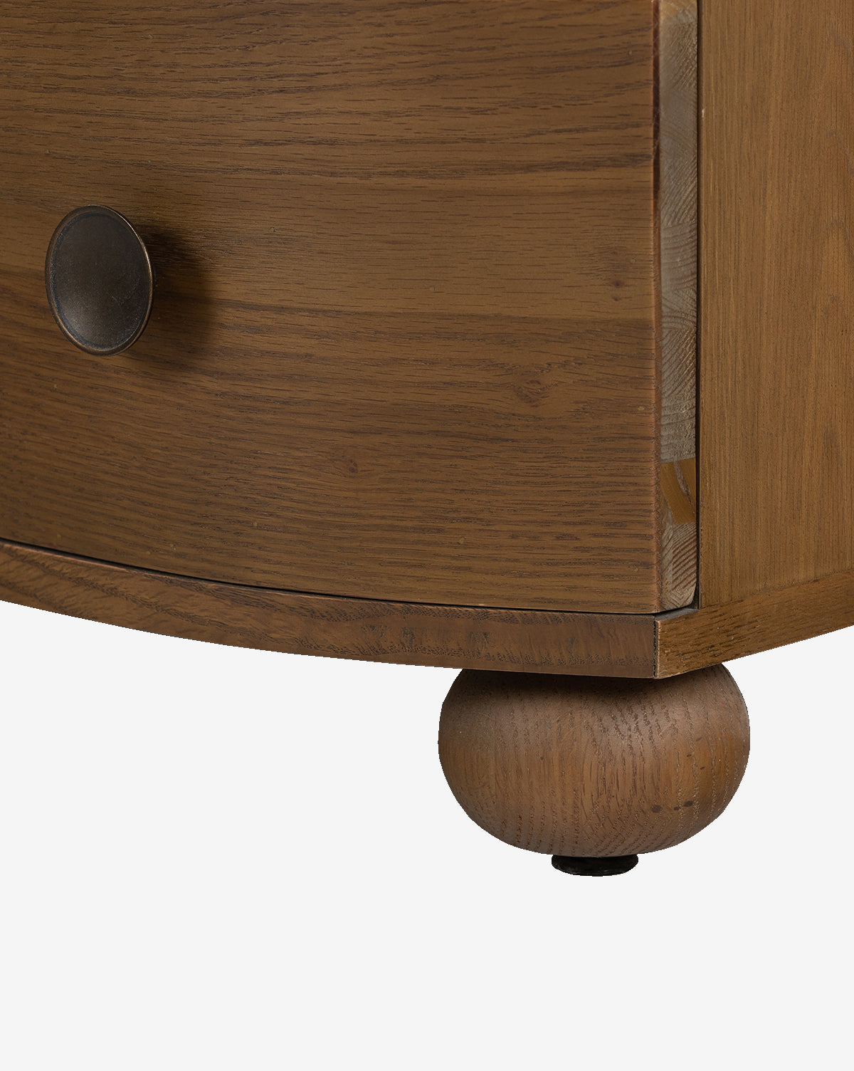 Close-up of the Strasburg Nightstand’s bottom corner, showing its round metal knob and spherical wood foot for a touch of elegance—ideal for stylish bedroom décor against a white background, by McGee & Co.