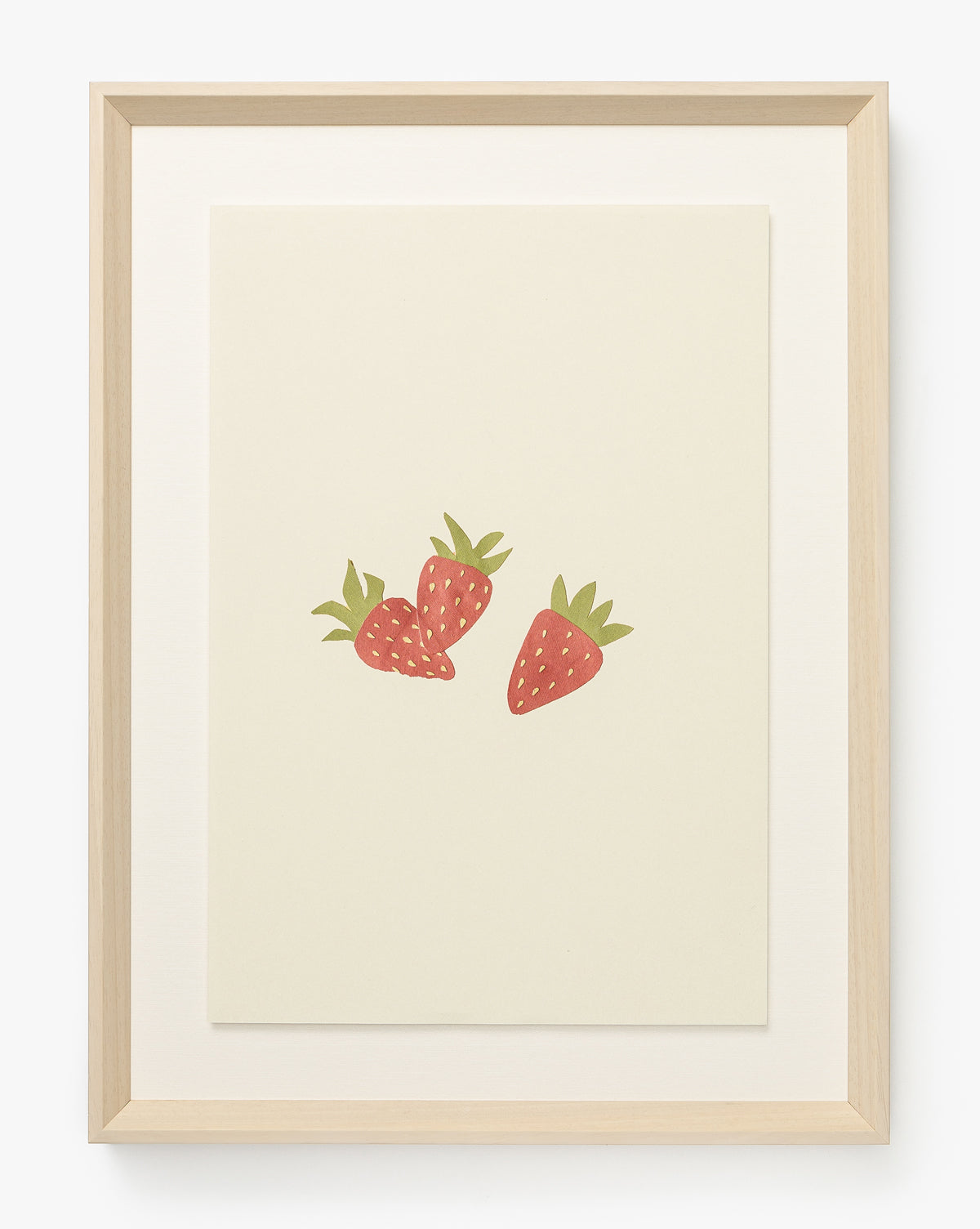 Strawberry Collage is a minimalist giclee print featuring three illustrated strawberries with green leaves on a cream background, framed in light wood—perfect for adding a cheerful touch to any children’s room, by McGee & Co.