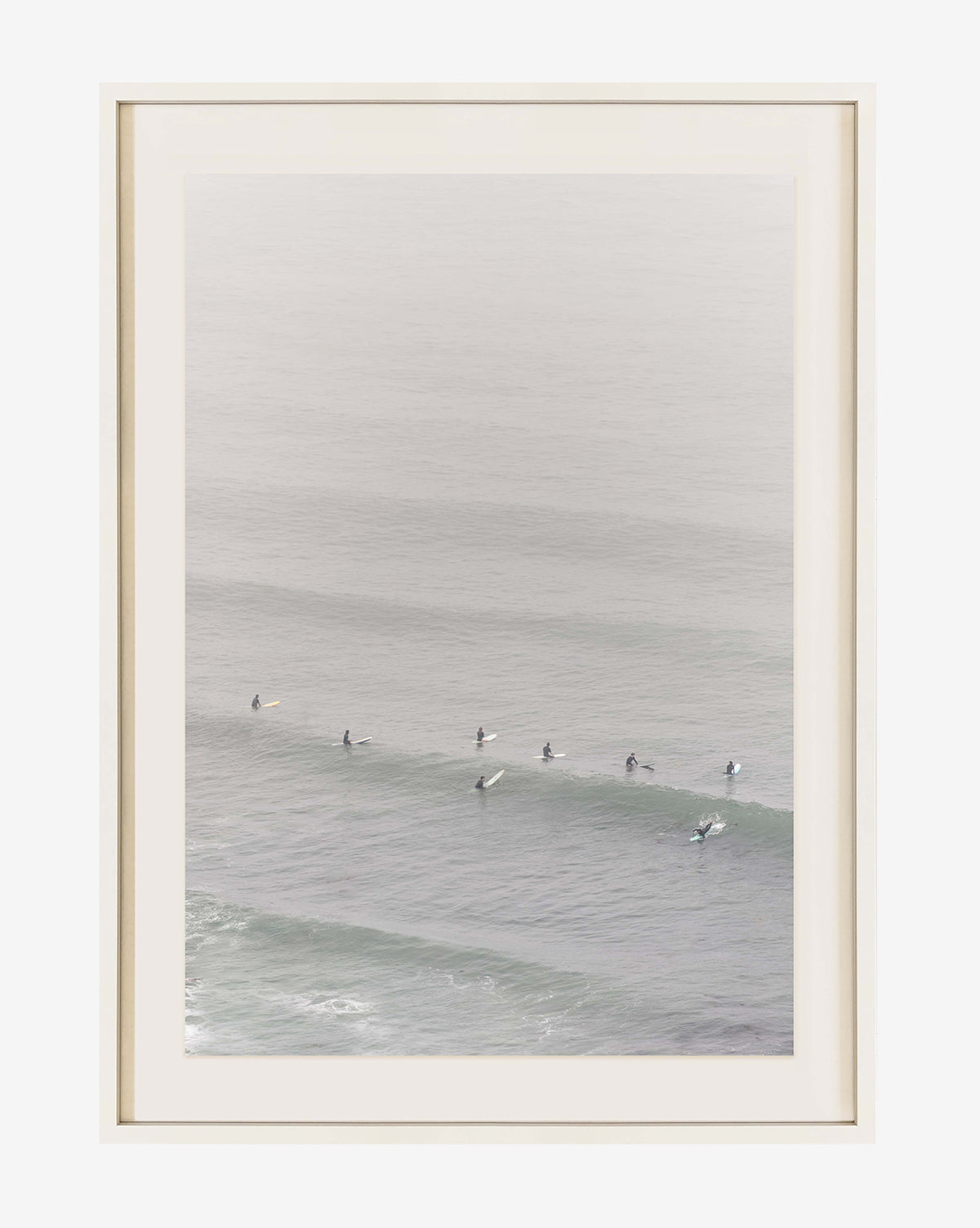 Surf Rider: a museum-grade framed original photograph, captured from above, features several surfers waiting on their boards in calm waves, rendered in a soft, muted color palette.