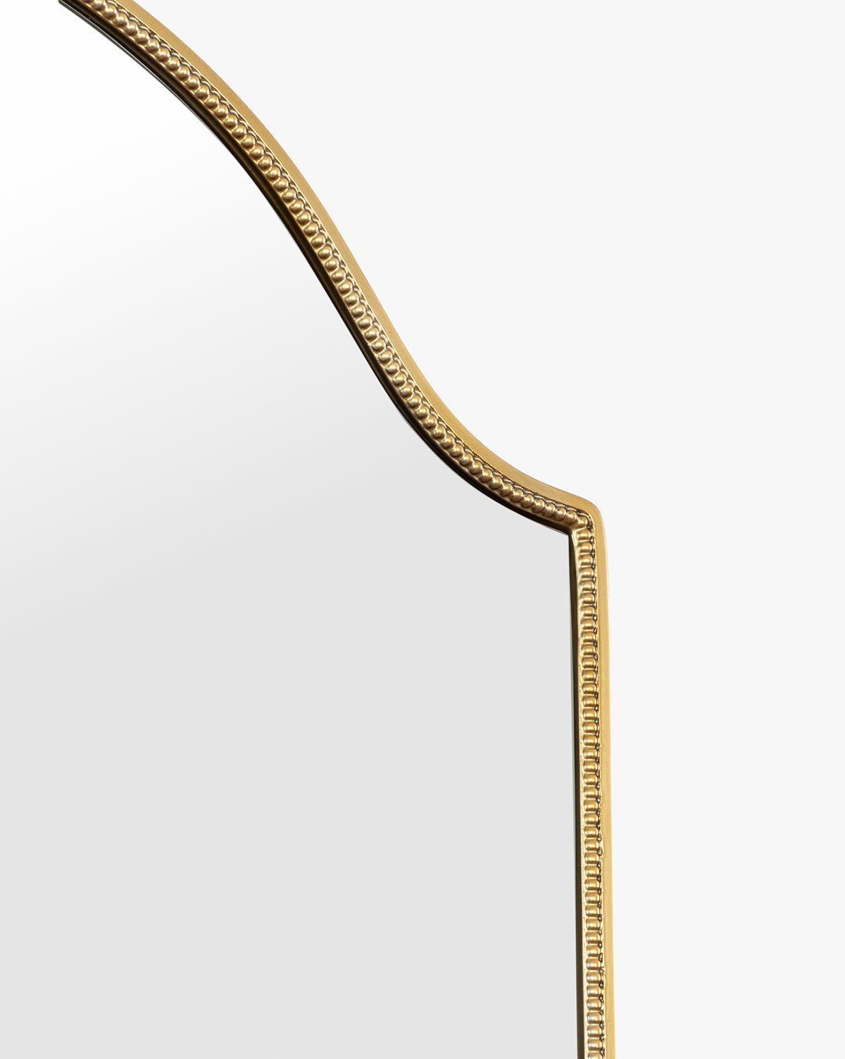 A close-up of the Sussex Floor Mirror shows its gold beaded, ornate frame and arched top set against a plain white background, by McGee & Co.