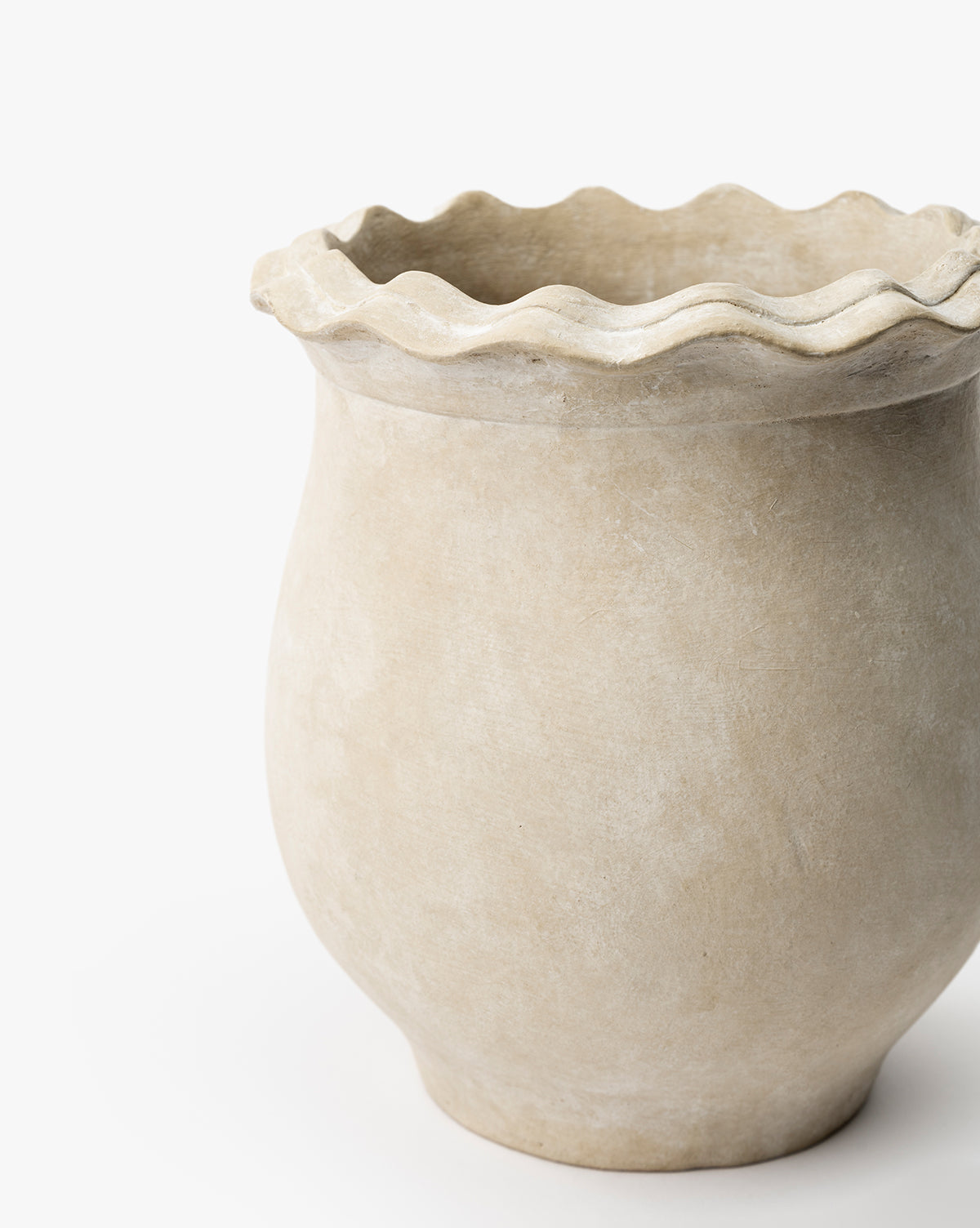 The Swansea Indoor Pot features a beige, wide-round body and wavy ruffled rim, ideal for indoor plant styling. Shown against a white background, by McGee & Co.