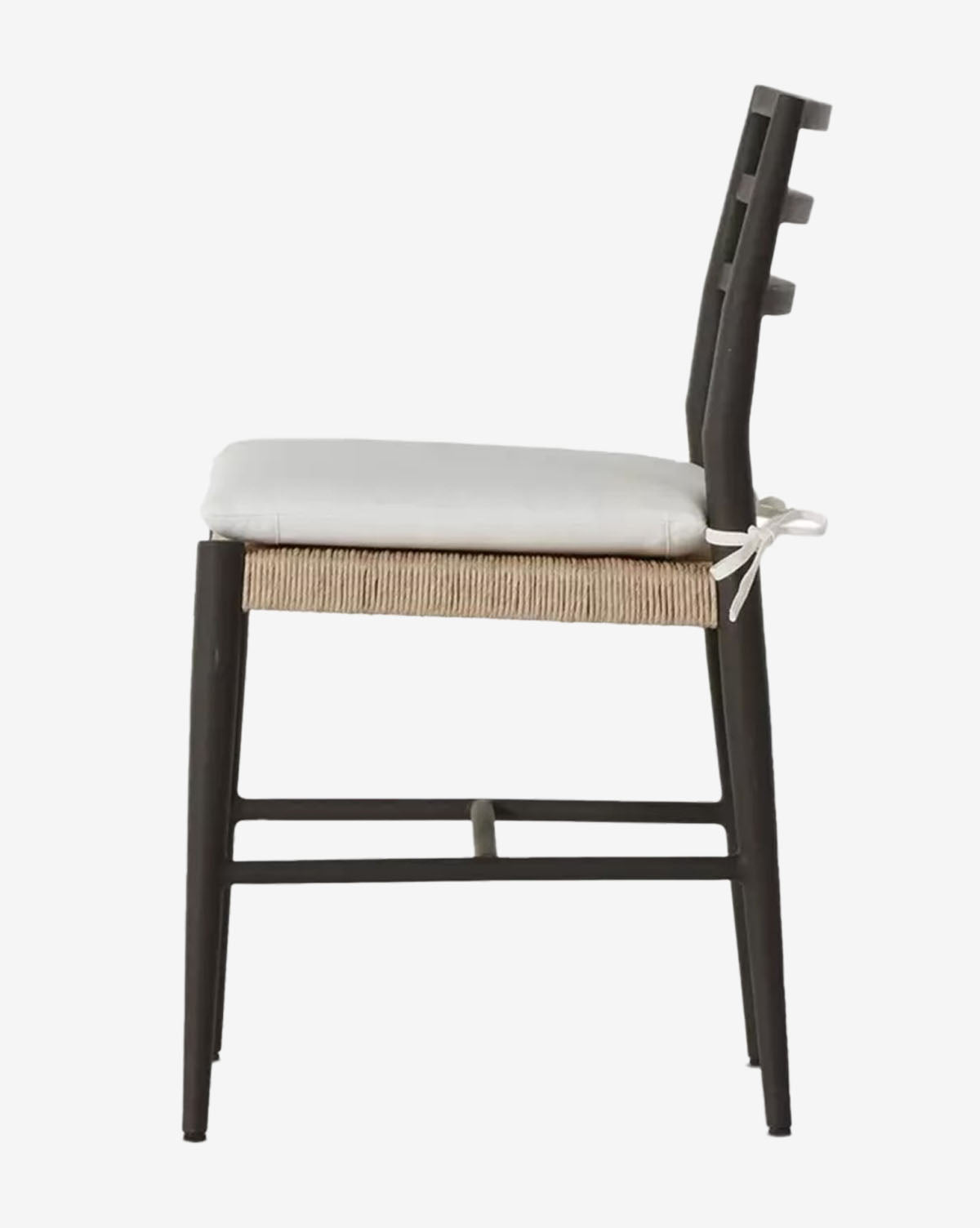 A side view of the Tabitha Outdoor Dining Chair shows its black wooden frame, woven seat, and a removable cushion tied to the backrest. The chair is designed with simple, clean lines and a modern, minimalist style, by McGee & Co.