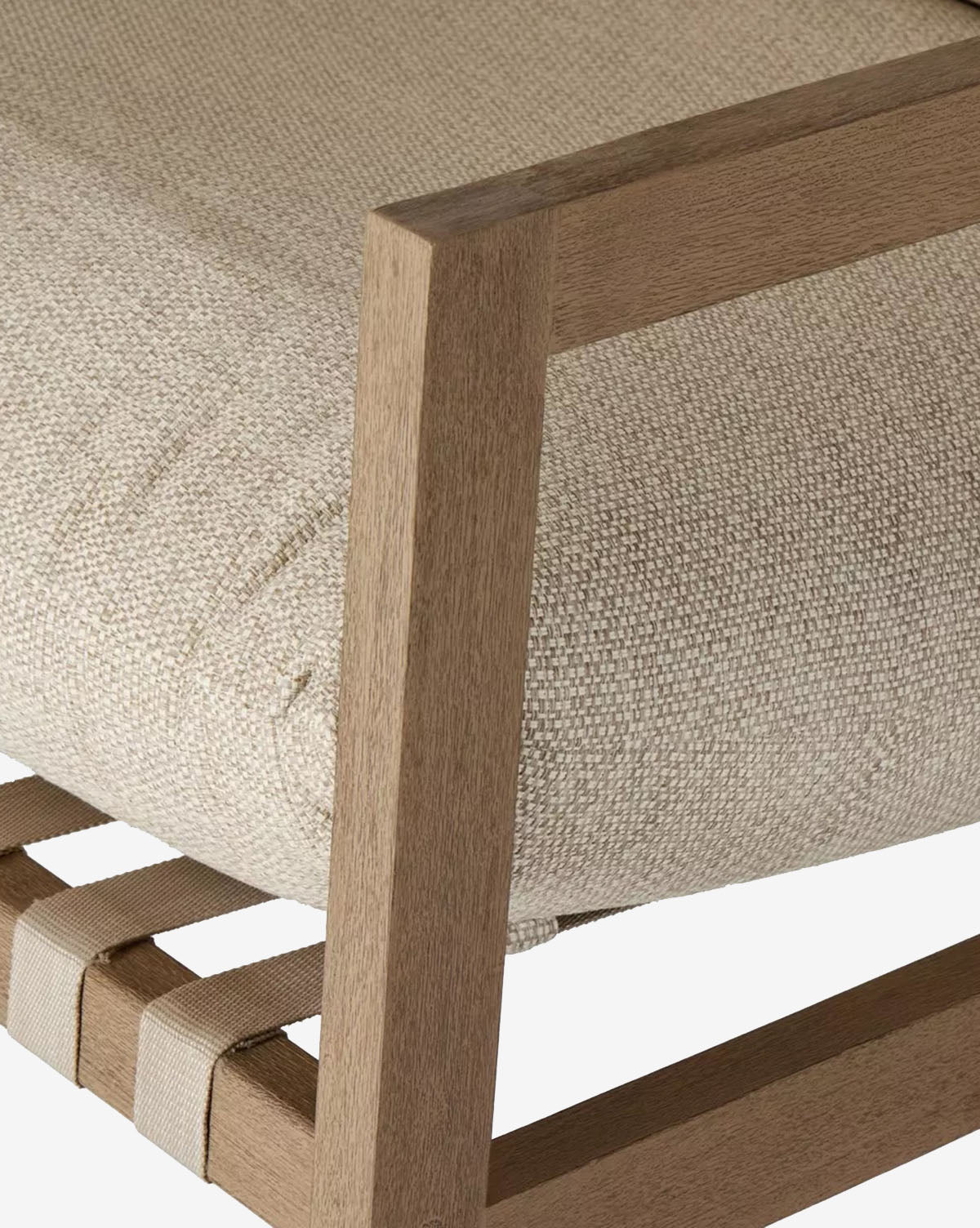 Close-up of the Talia Outdoor Rocking Chair’s teak frame, featuring a textured beige cushion and fabric webbing underneath. The detailed corner joint and upholstery make it an elegant backyard furniture choice, by McGee & Co.